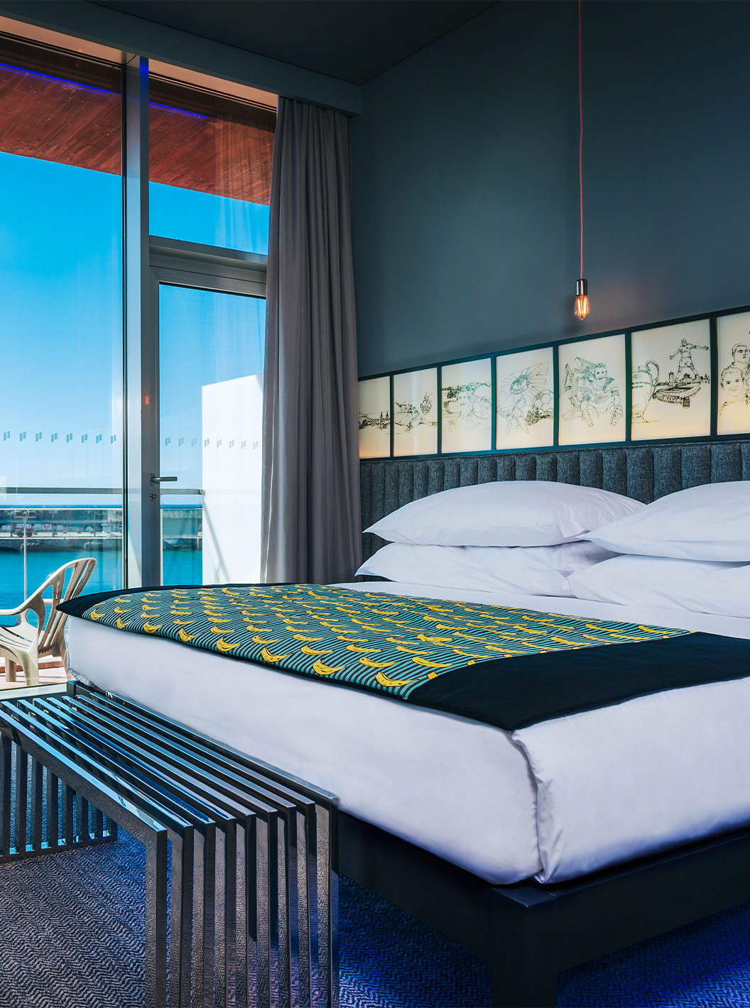 The CR Superior Room at Pestana CR7 Funchal features a balcony beside the double bed, with two chairs and sea view