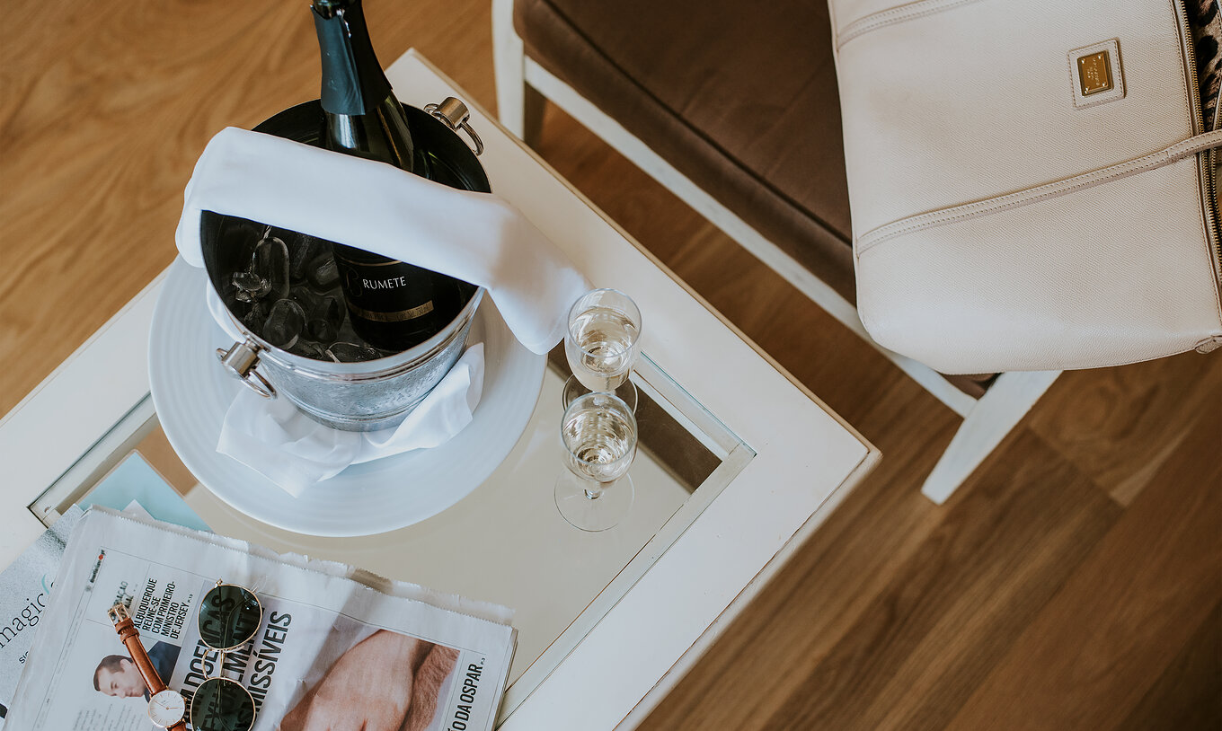 The T2 Apartment at Pestana Madeira Beach Club has a table with champagne on ice, newspapers and a chair