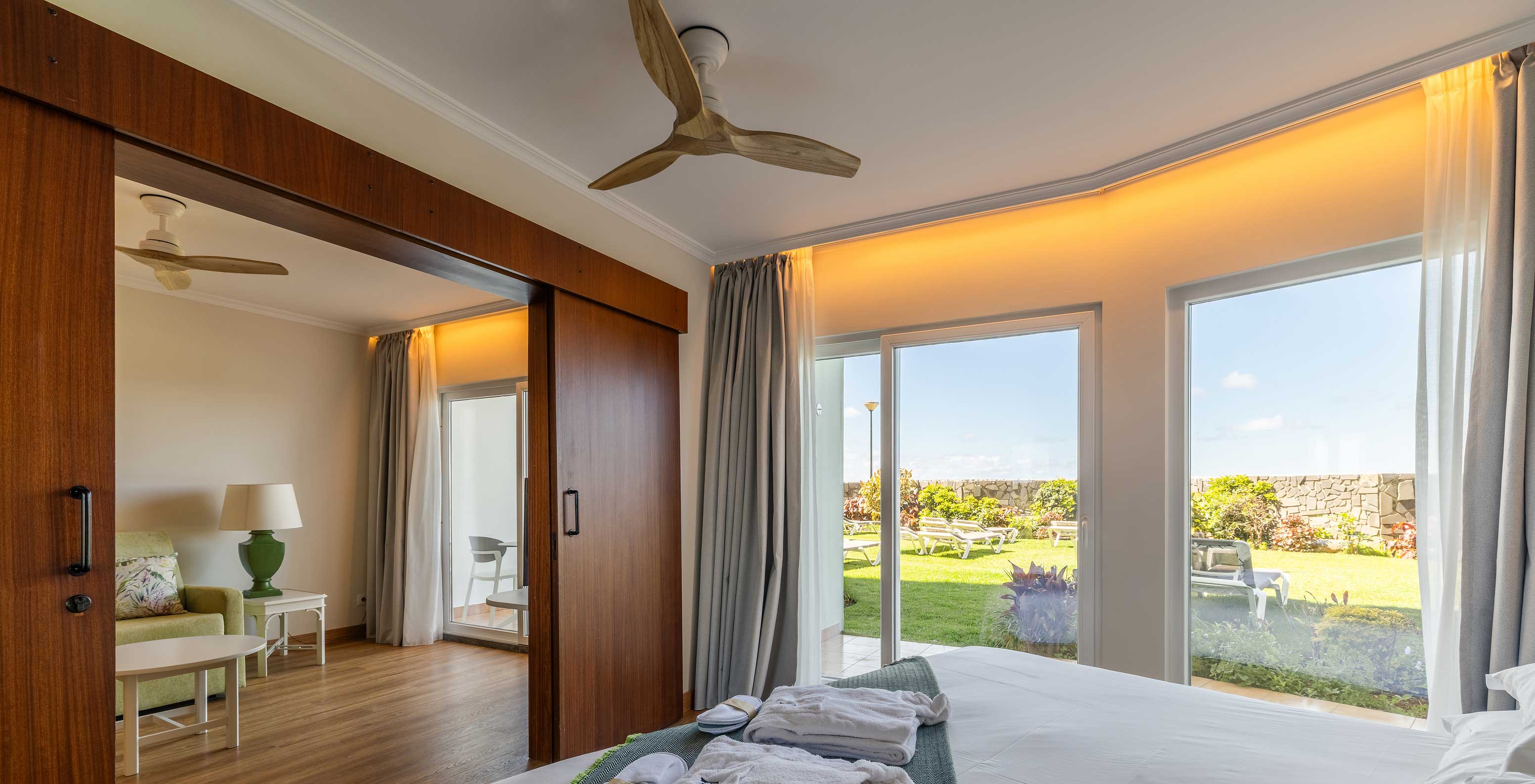 The Pestana Ocean Bay All Inclusive Junior Suite Sea View has a double bed with a garden view and a living room