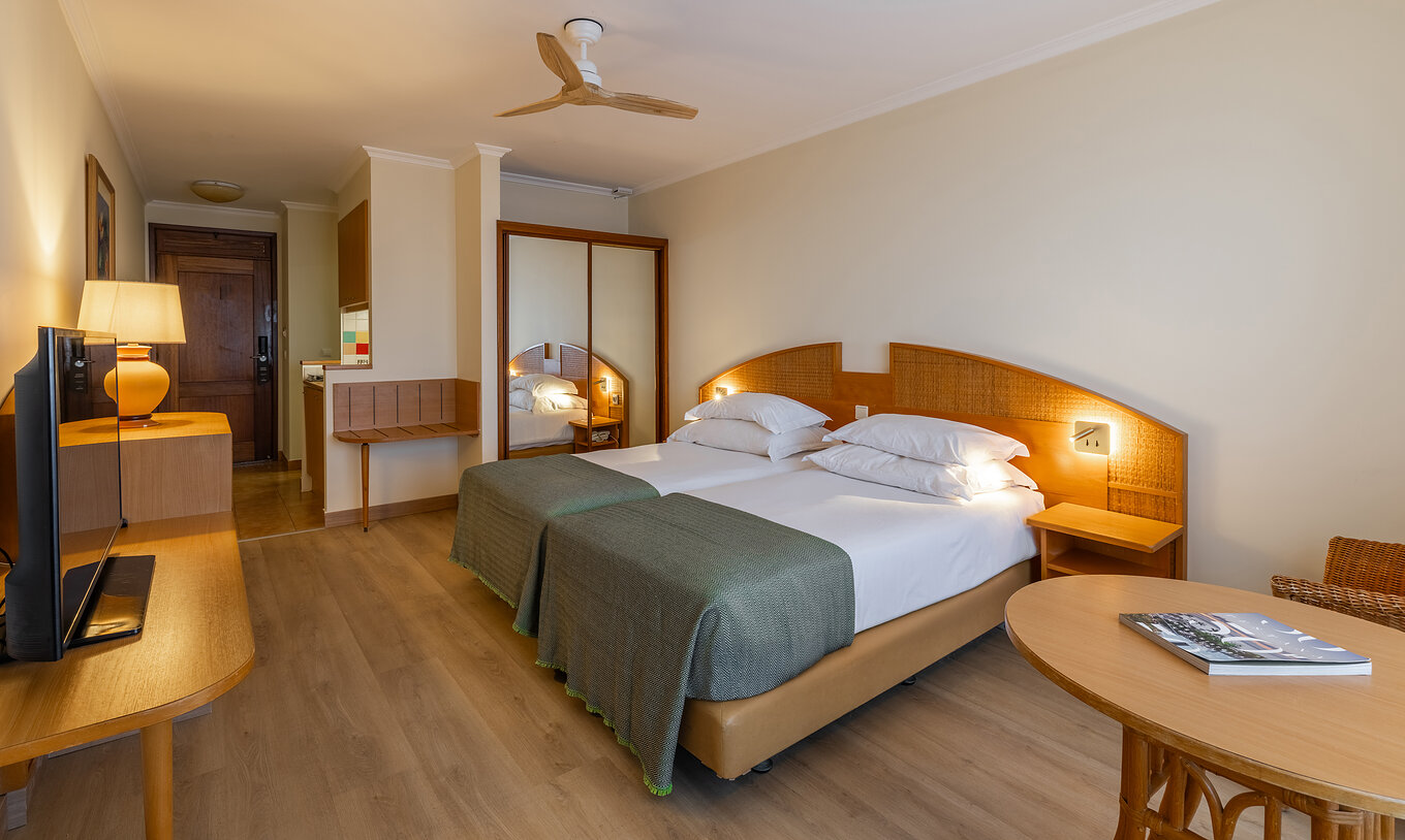 The Pestana Ocean Bay All Inclusive Classic Sea View has two single beds joined together, a wardrobe with a mirror and a TV