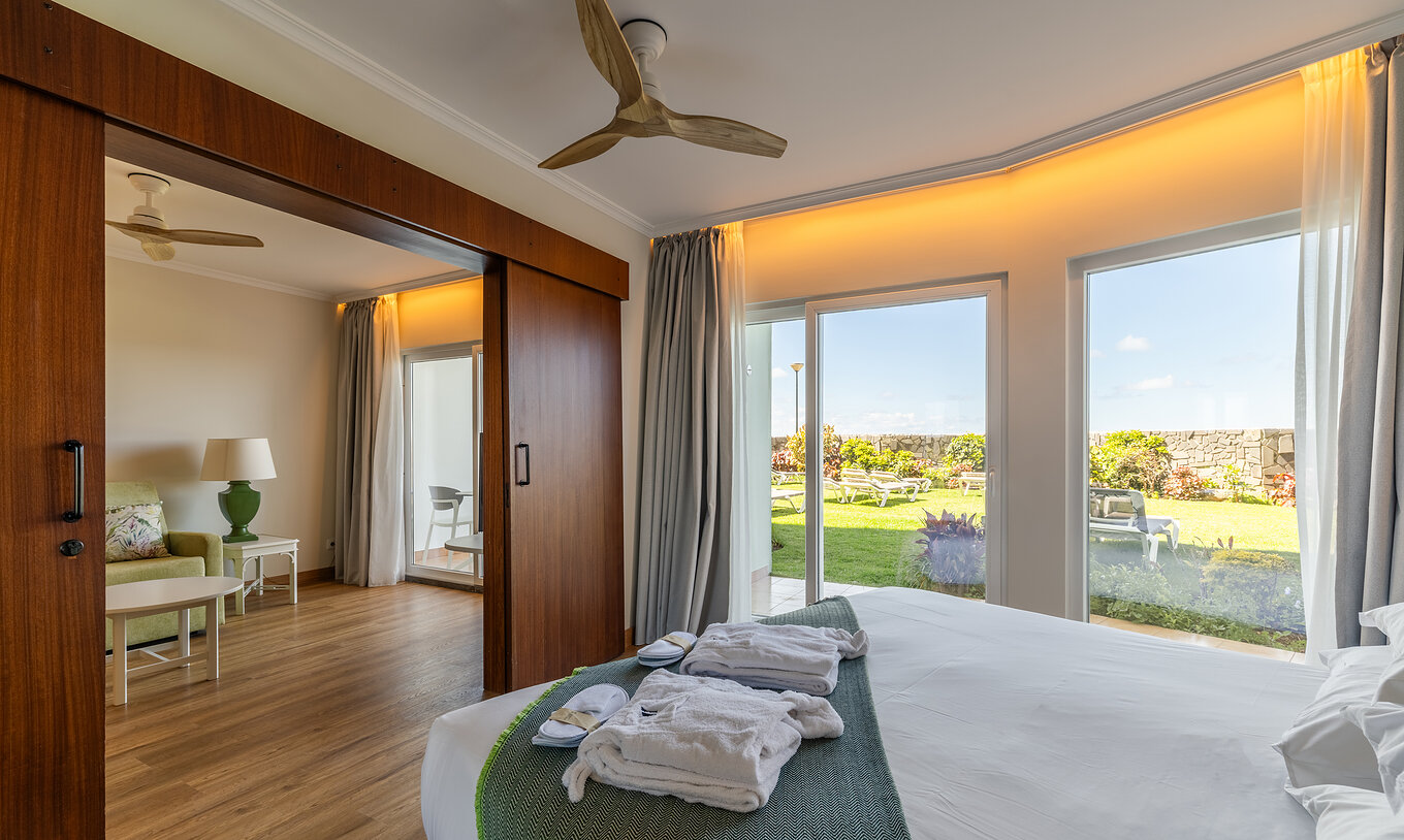 The Pestana Ocean Bay All Inclusive Junior Suite Sea View has a double bed with a garden view and a living room