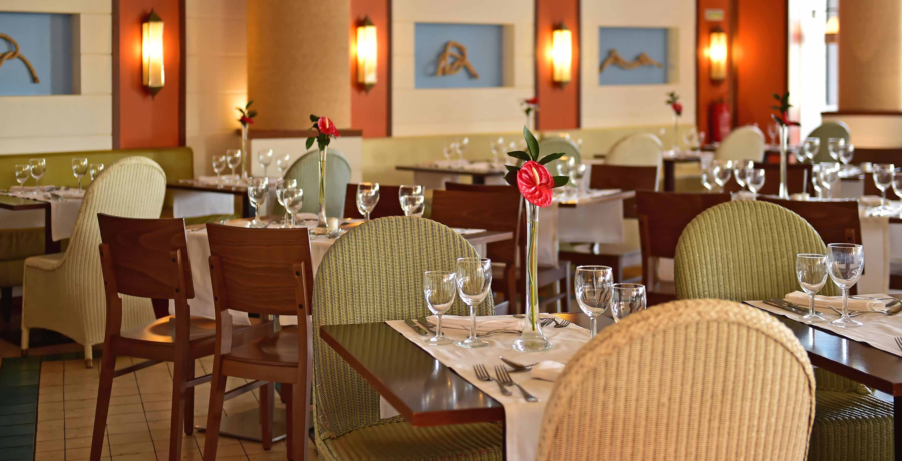 Marés Restaurant, 5-star Resort in Porto Santo has a space with green chairs and wooden tables