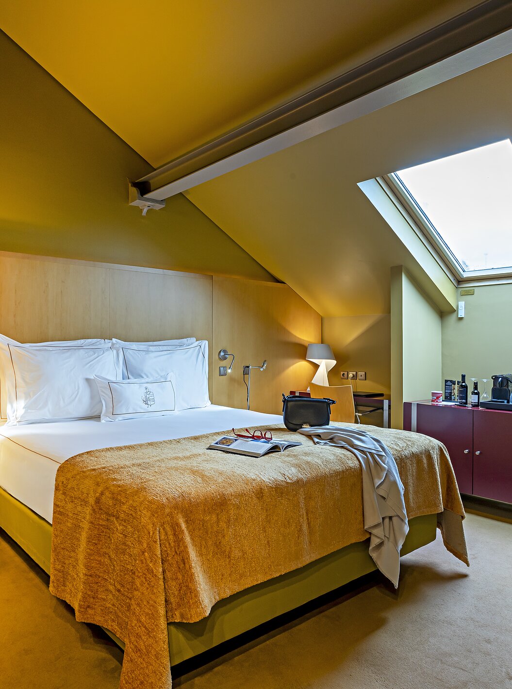 Pestana Palácio do Freixo’s Classic Attic has a bed with a yellow cover and a red bedside table