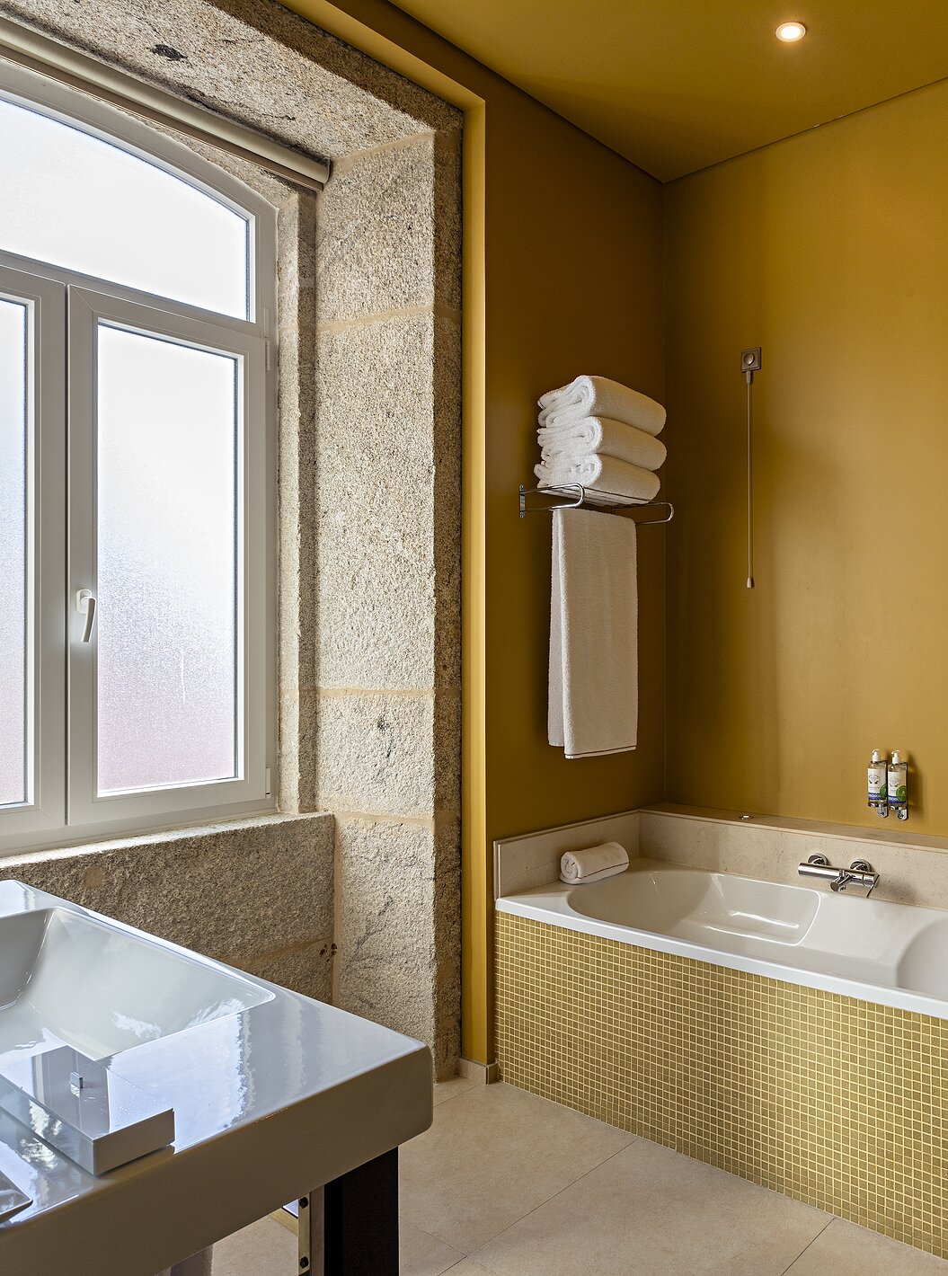 The Suite Nasoni has a bathroom with yellow tiles, a bathtub, and shower area