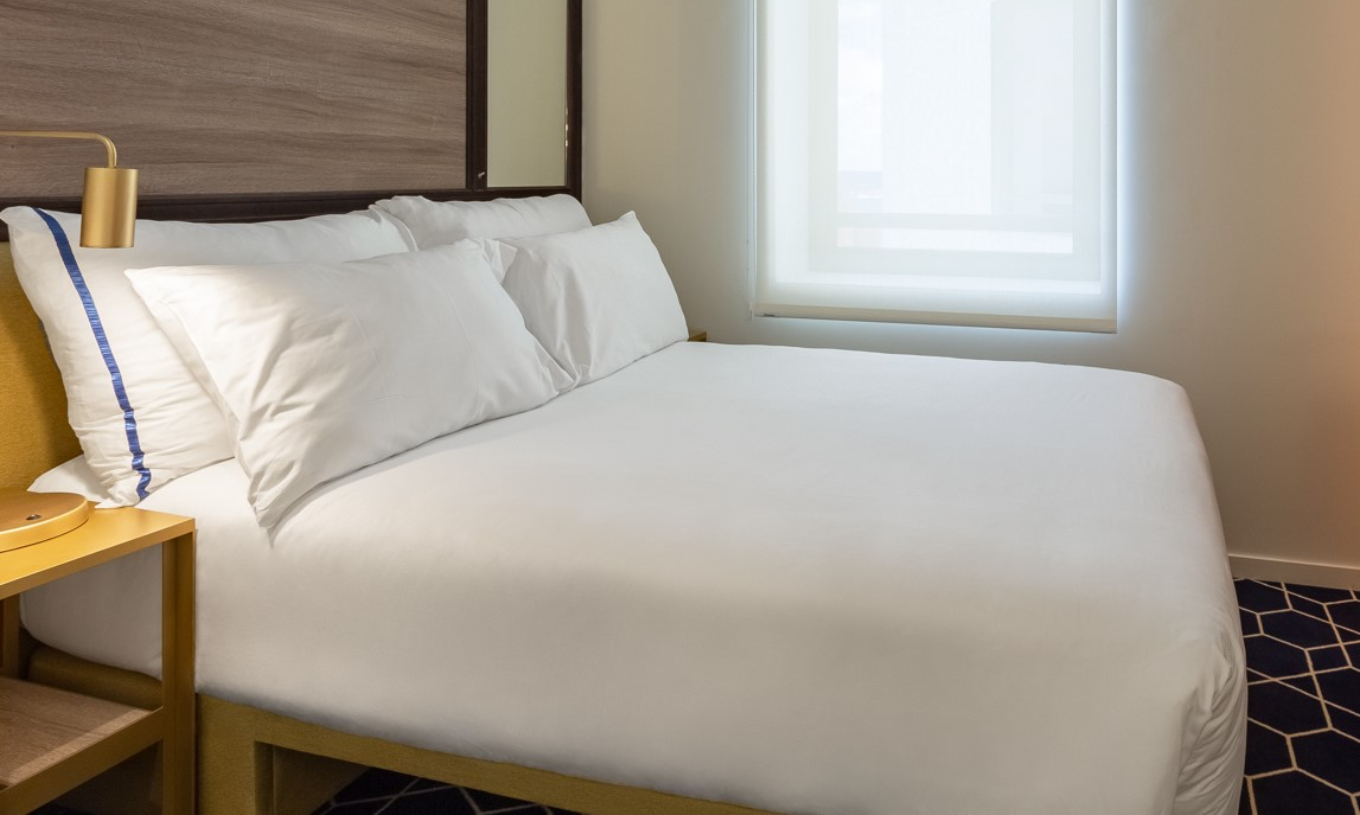 The Small Double Room at Pestana CR7 Gran Vía Madrid has a double bed, a window, and a yellow bedside table