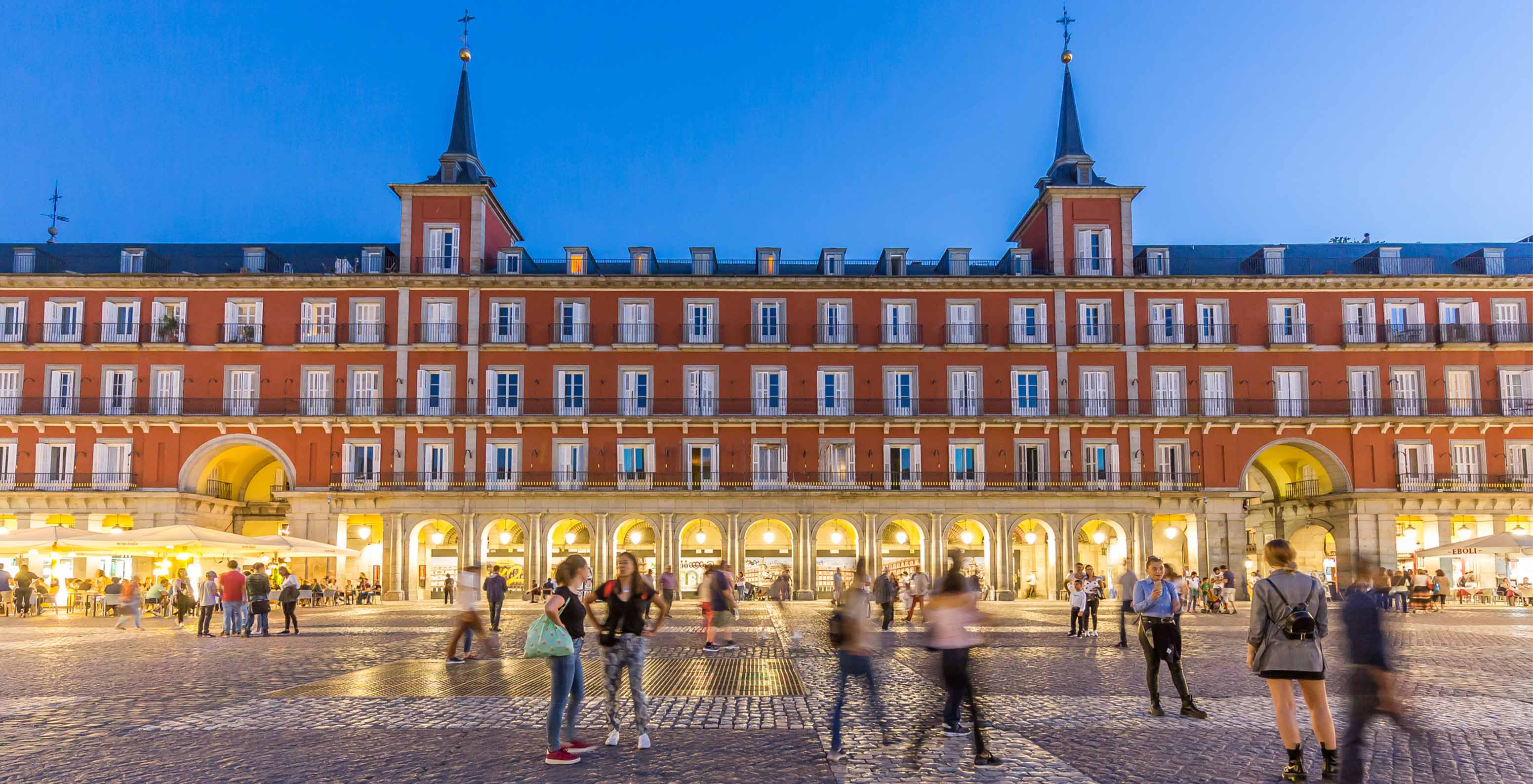 Facade of Pestana Collection Plaza Mayor illuminated at night, painted in red tones