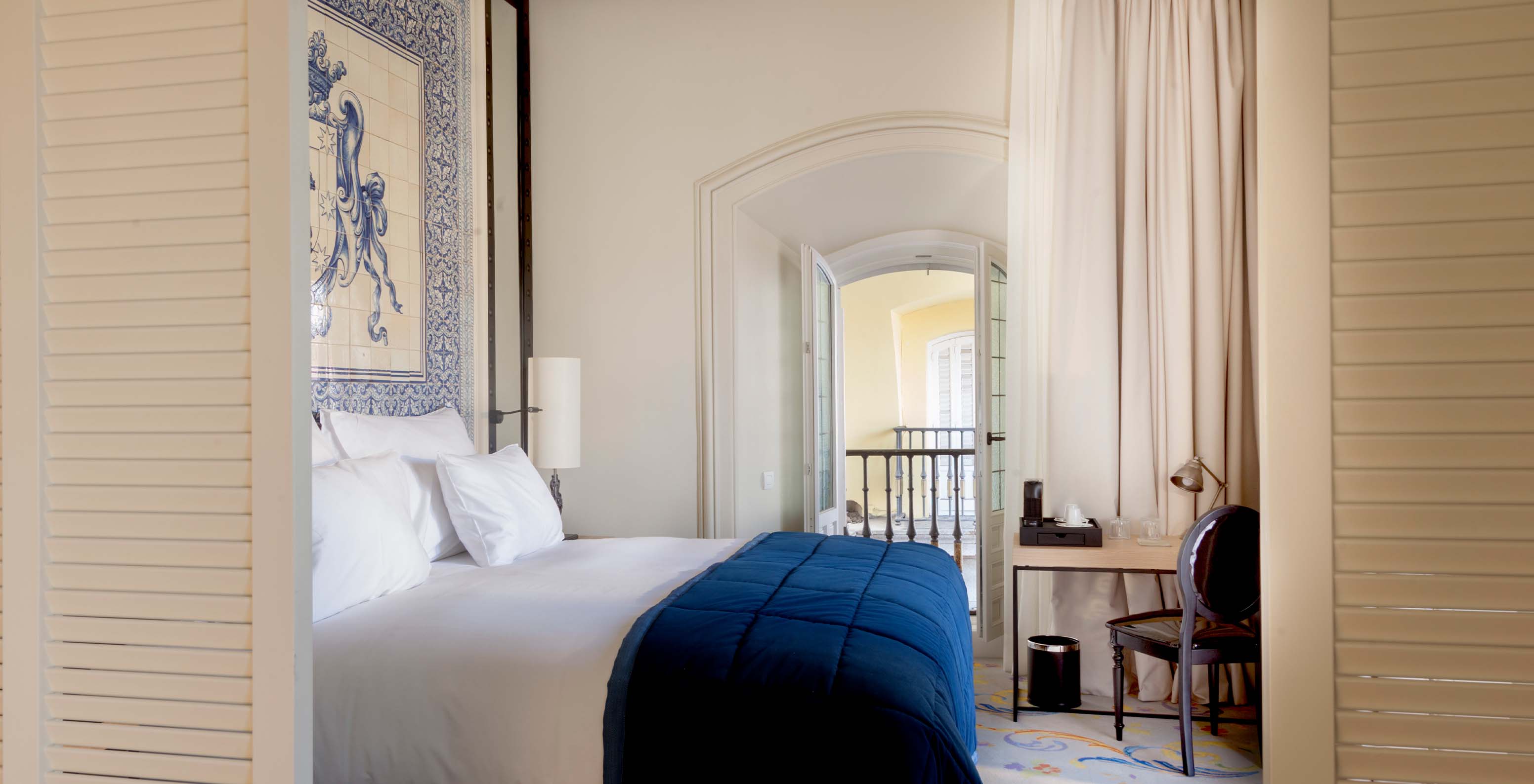The Suite Plaza Mayor at Pestana Collection Plaza Mayor has a double bed and a headboard with blue and white tiles
