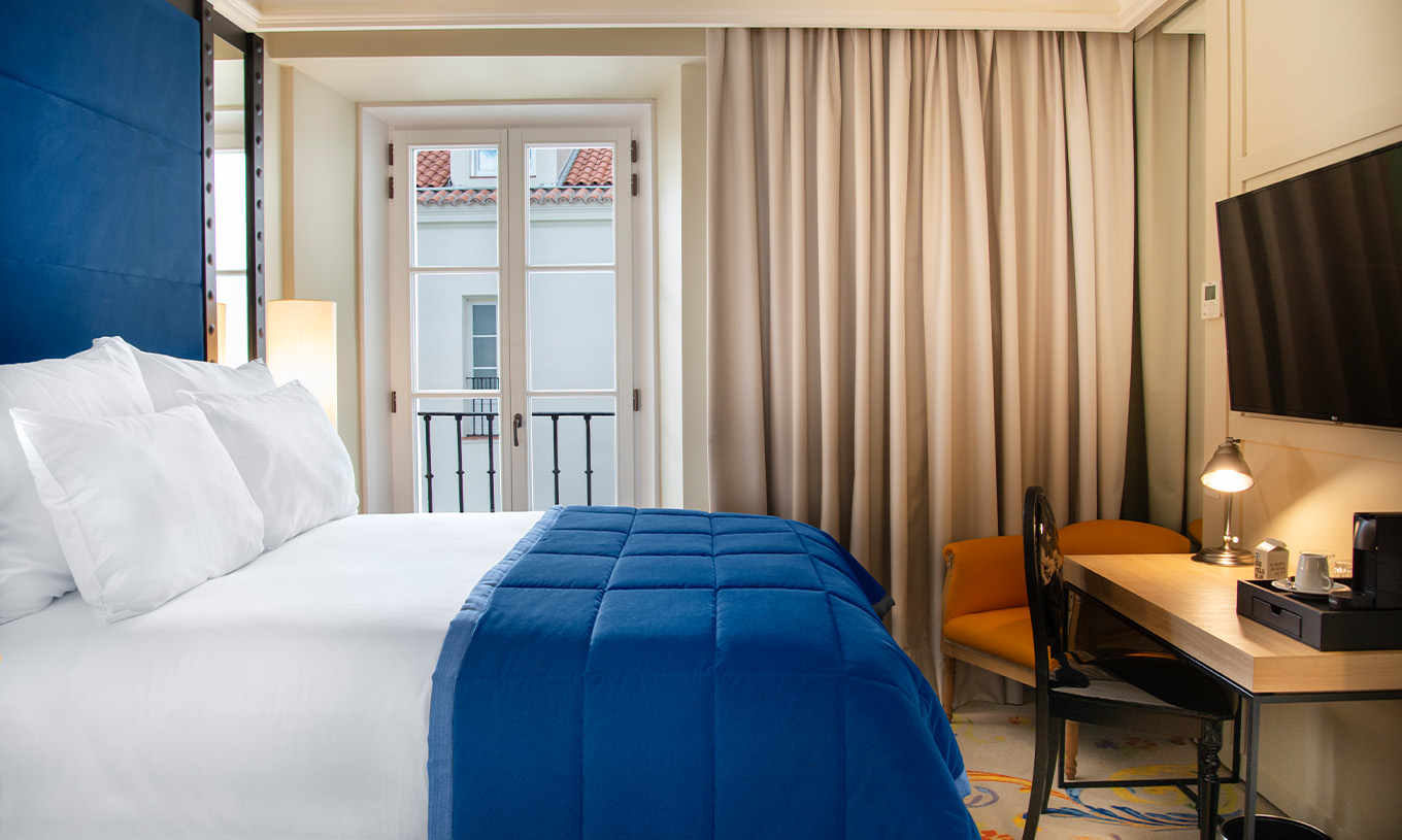 The Classic Room at Pestana Plaza Mayor Madrid has a double bed, TV, desk and a window with curtains