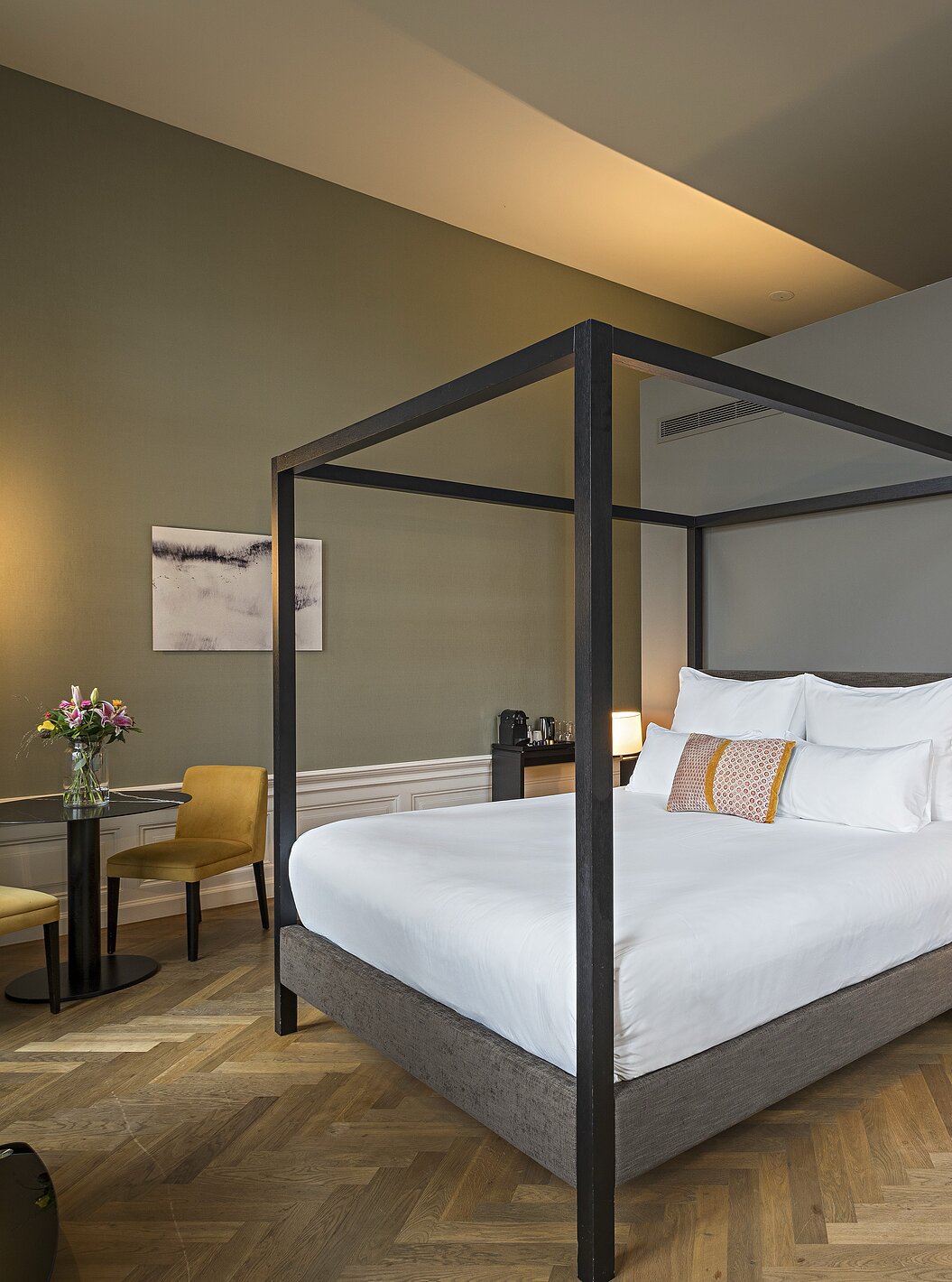 Junior Suite - River View at Pestana Amsterdam Riverside has a double bed with canopy and a table with two chairs