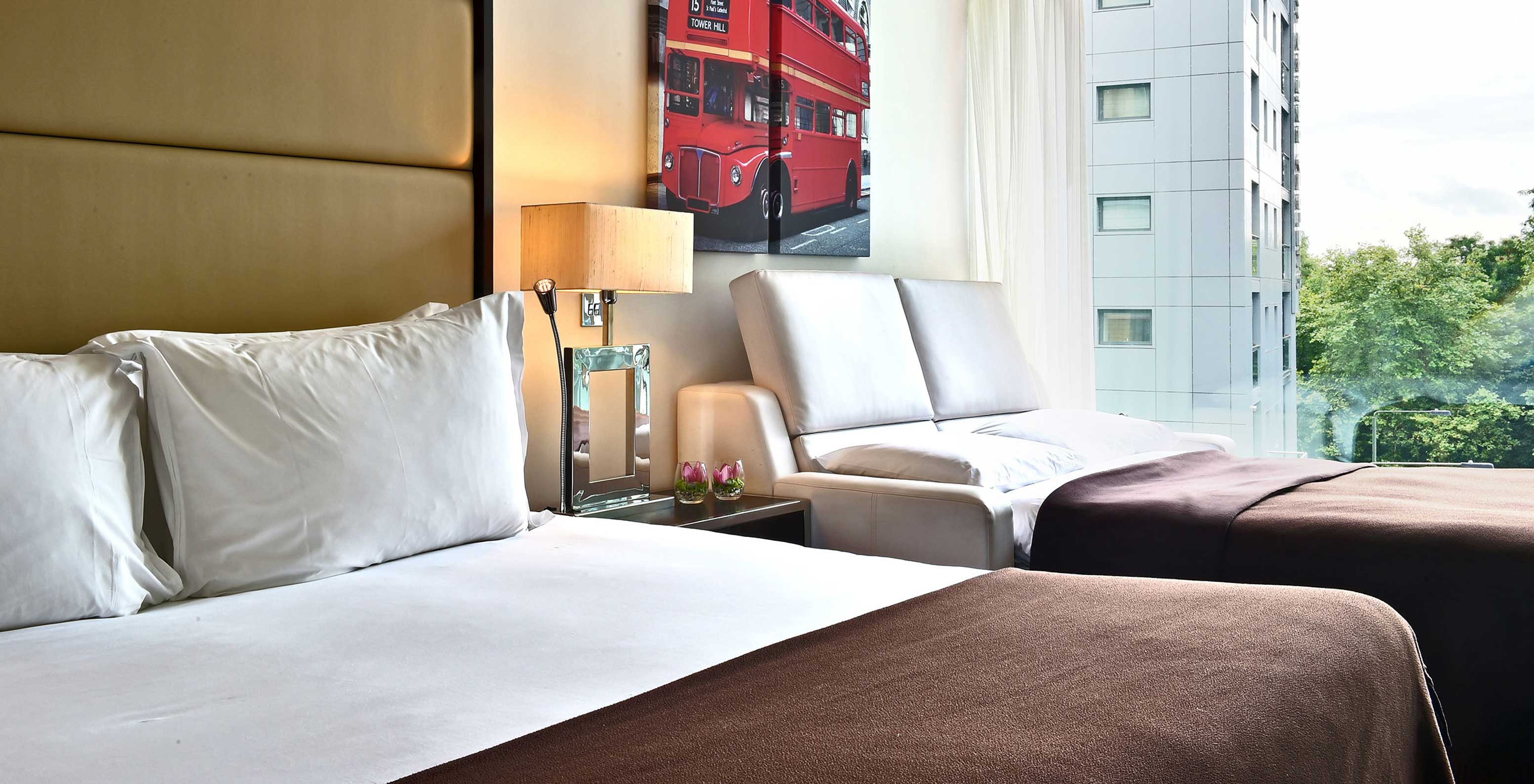 The Deluxe Family at Pestana Chelsea Bridge has a double bed, open sofa bed, London art and a window with view