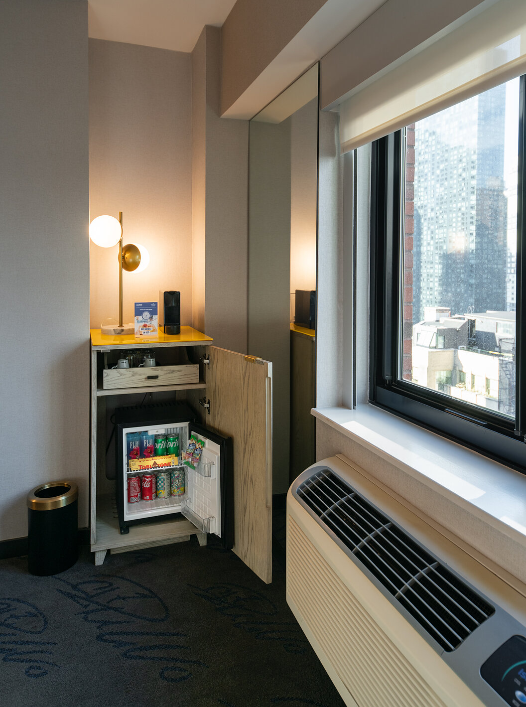 The Deluxe King Room at Pestana CR7 Times Square has a wardrobe with a minibar by the window
