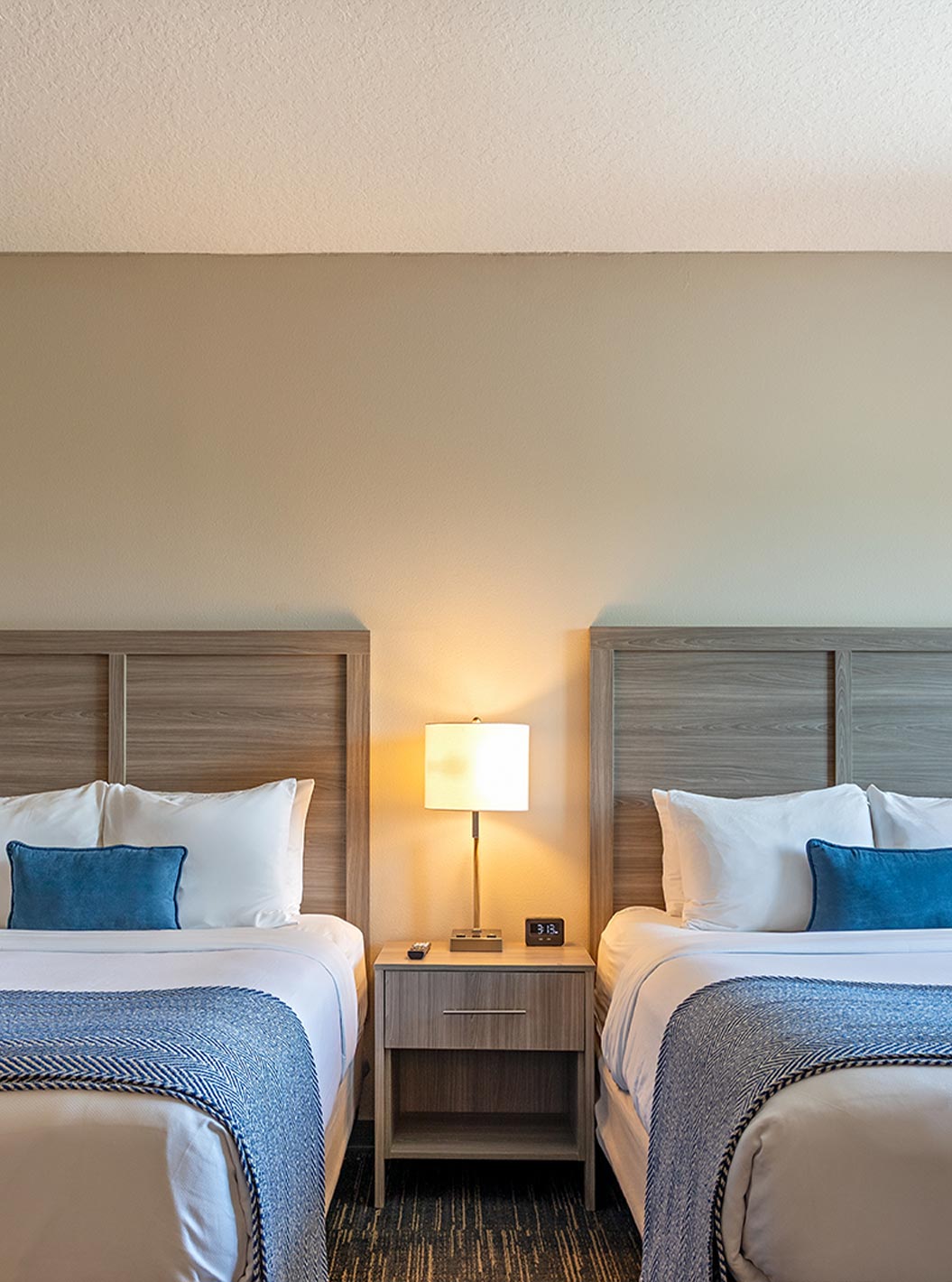 Connected King and Double Queen Superior Suites at Pestana Orlando Suites Lake Buena Vista with two beds and bedside lamps