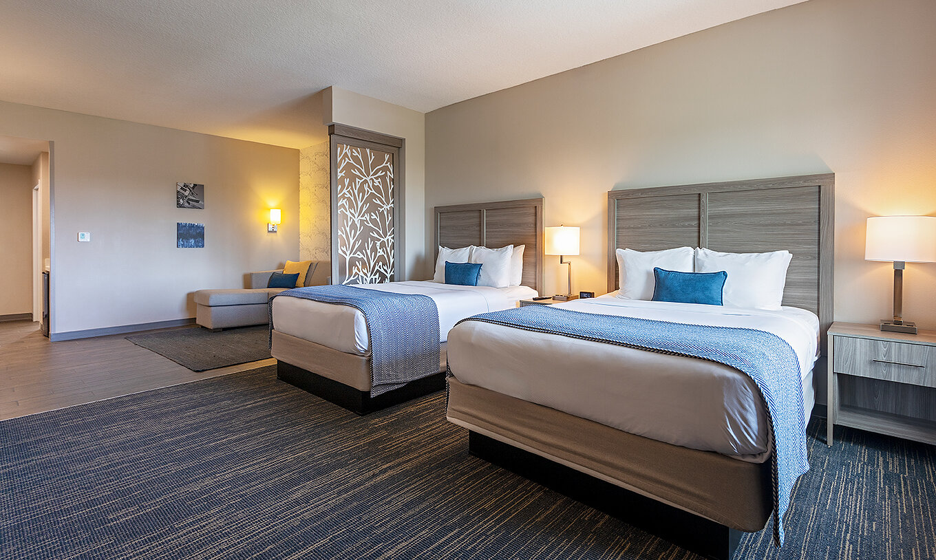 Double Queen Master Suite at Pestana Orlando Suites Lake Buena Vista with two beds, lamps and seating area