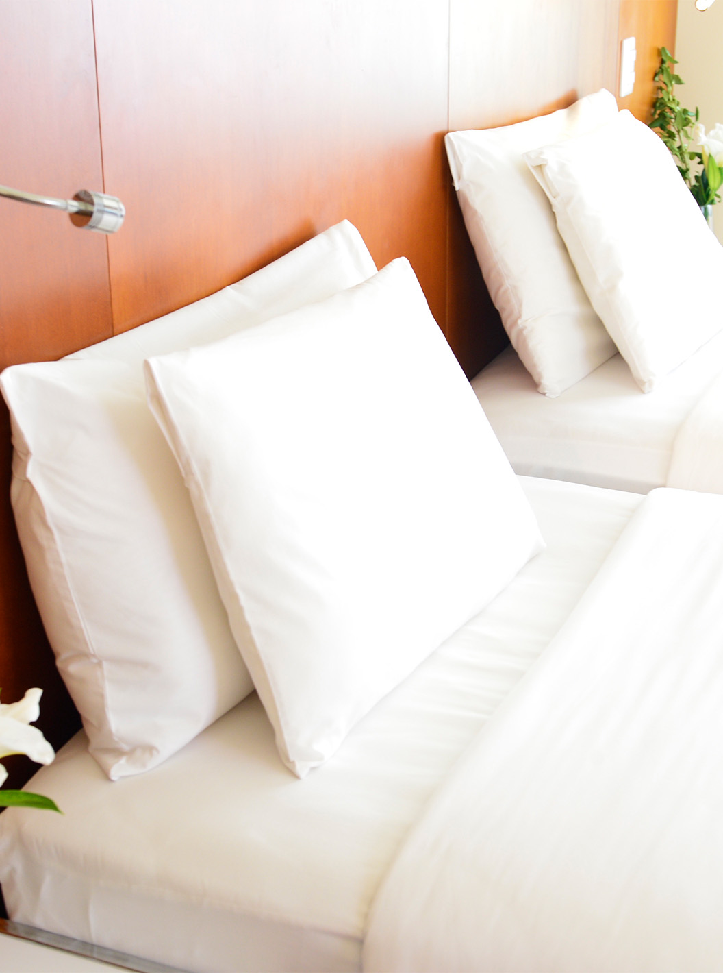 The Twin Executive Room at Pestana Caracas has two beds with white sheets, pillows, and a flower on the bedside table