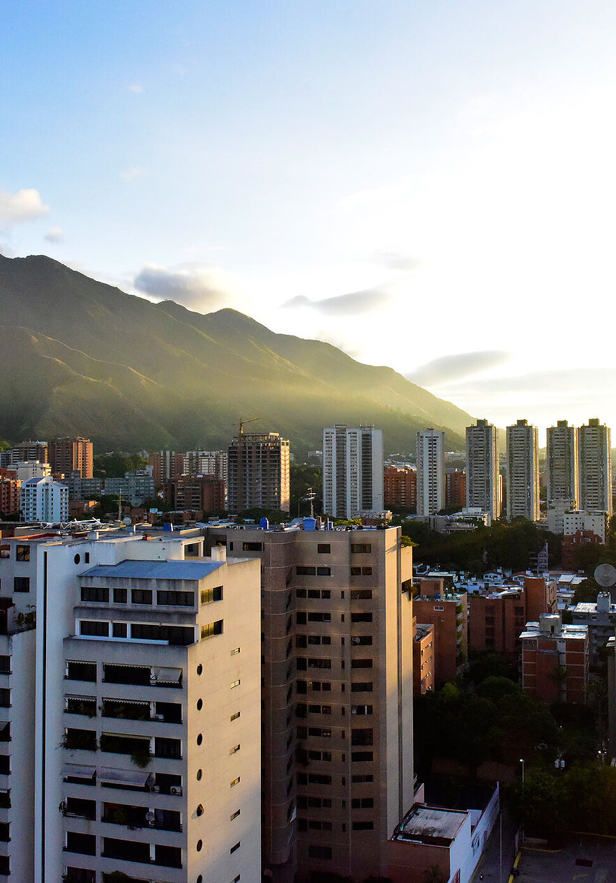 Discover Venezuela, a country full of natural beauty and vibrant culture, with tall buildings and lush green mountains.