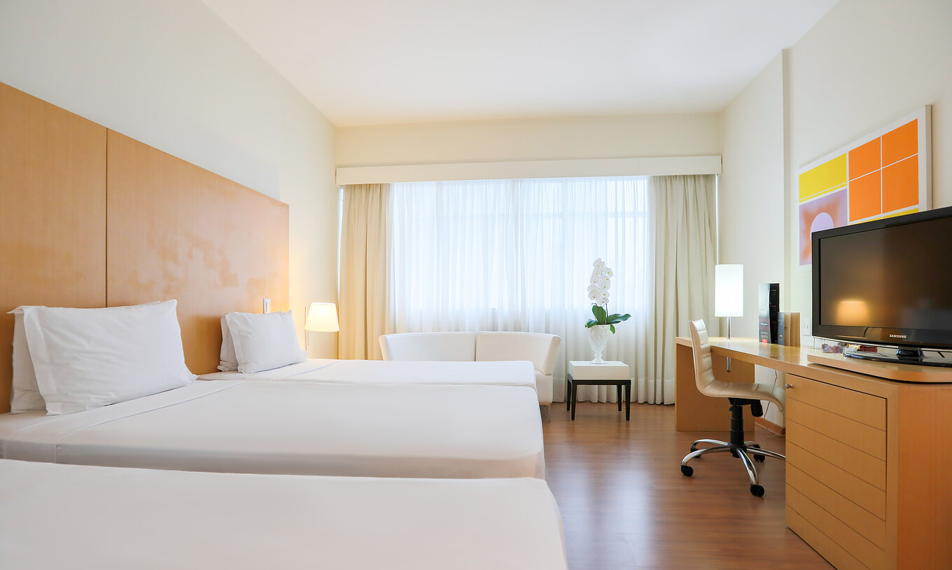 The Twin Luxury Corner at Pestana Curitiba accommodates three people with single beds and a double sofa by the window