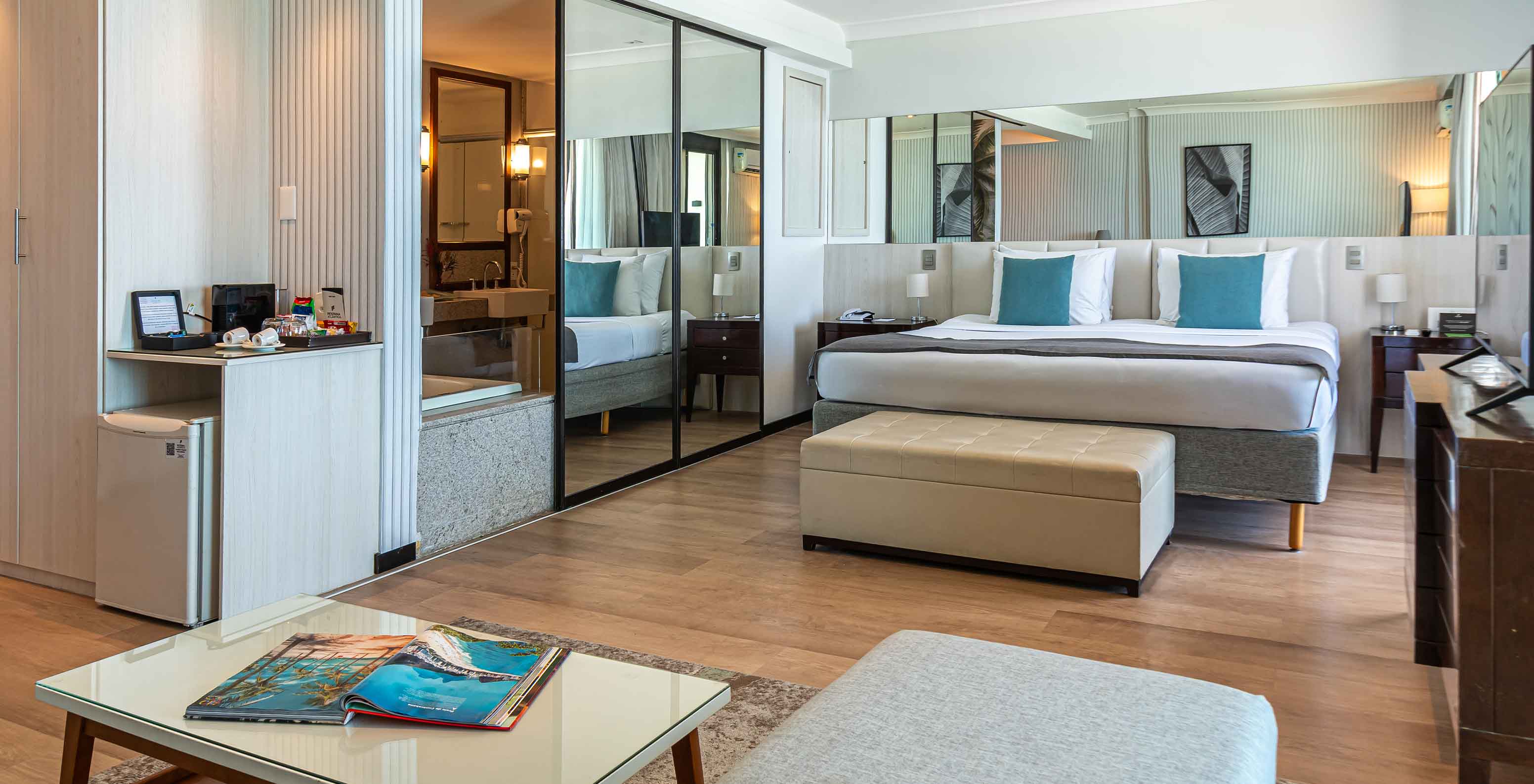 The Oceanic Suite at Pestana Rio Atlântica has a modern room with large bed, mirror and lounge.
