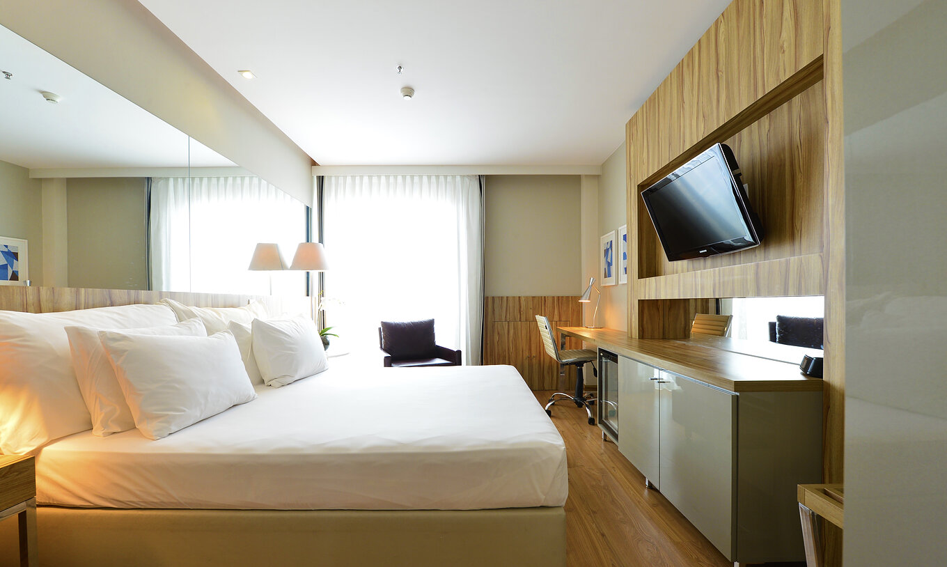 The Standard Double Room of Pestana Rio Atlântica has a double bed, a television, a desk, and an armchair