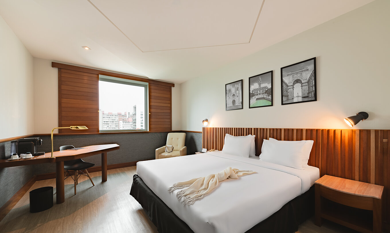 The Deluxe of Pestana São Paulo has a double bed and a window with a view of downtown São Paulo