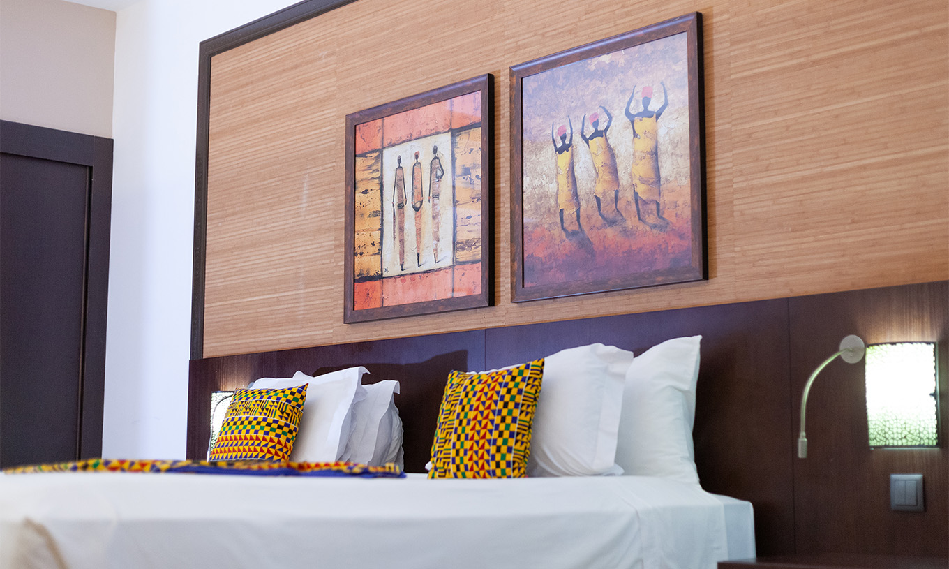 The Premium room at Pestana Tropico features two art pieces above the double bed and a bedside table