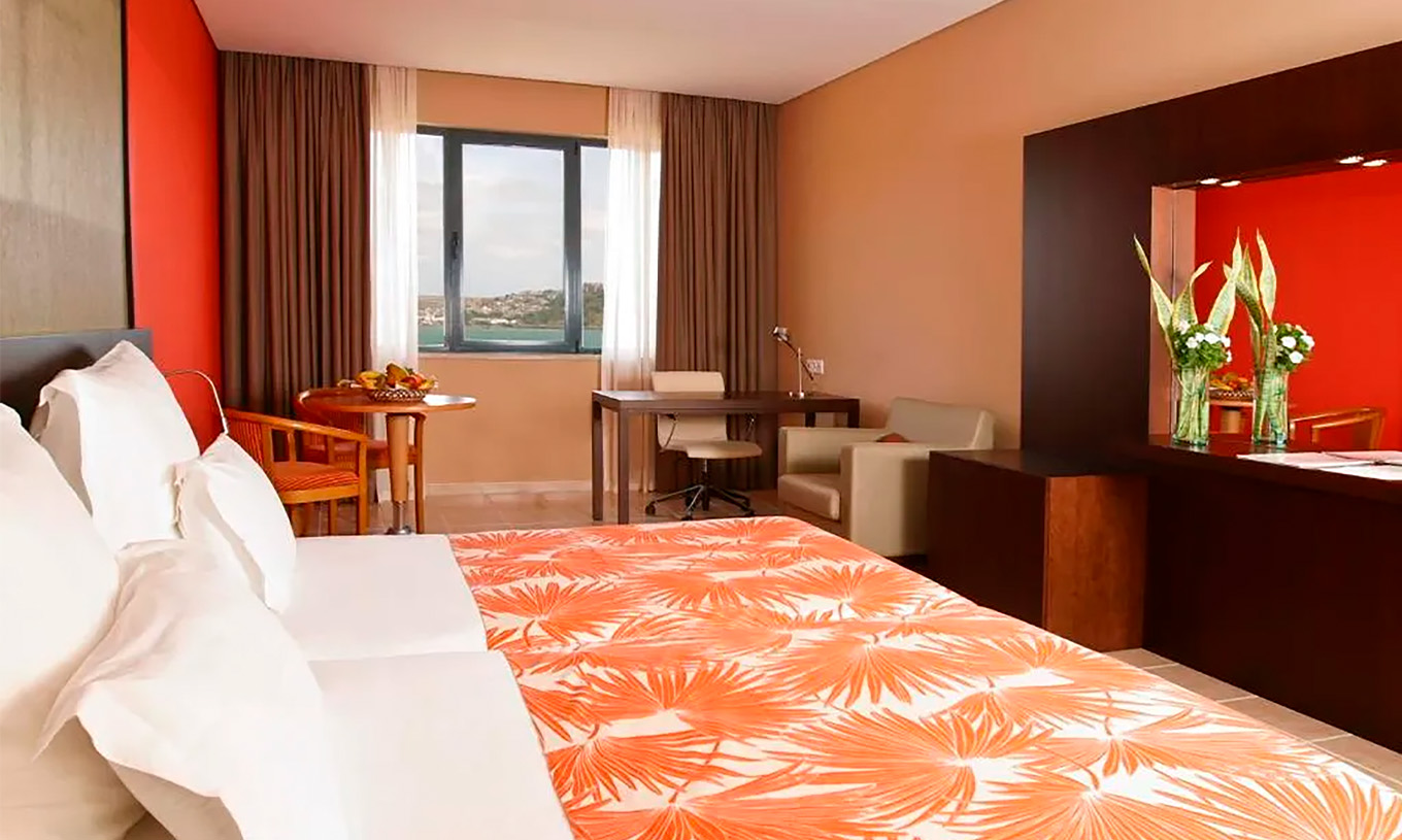 The Premium Suite at Pestana Tropico features two single beds, desk with chair, a table, and sea view