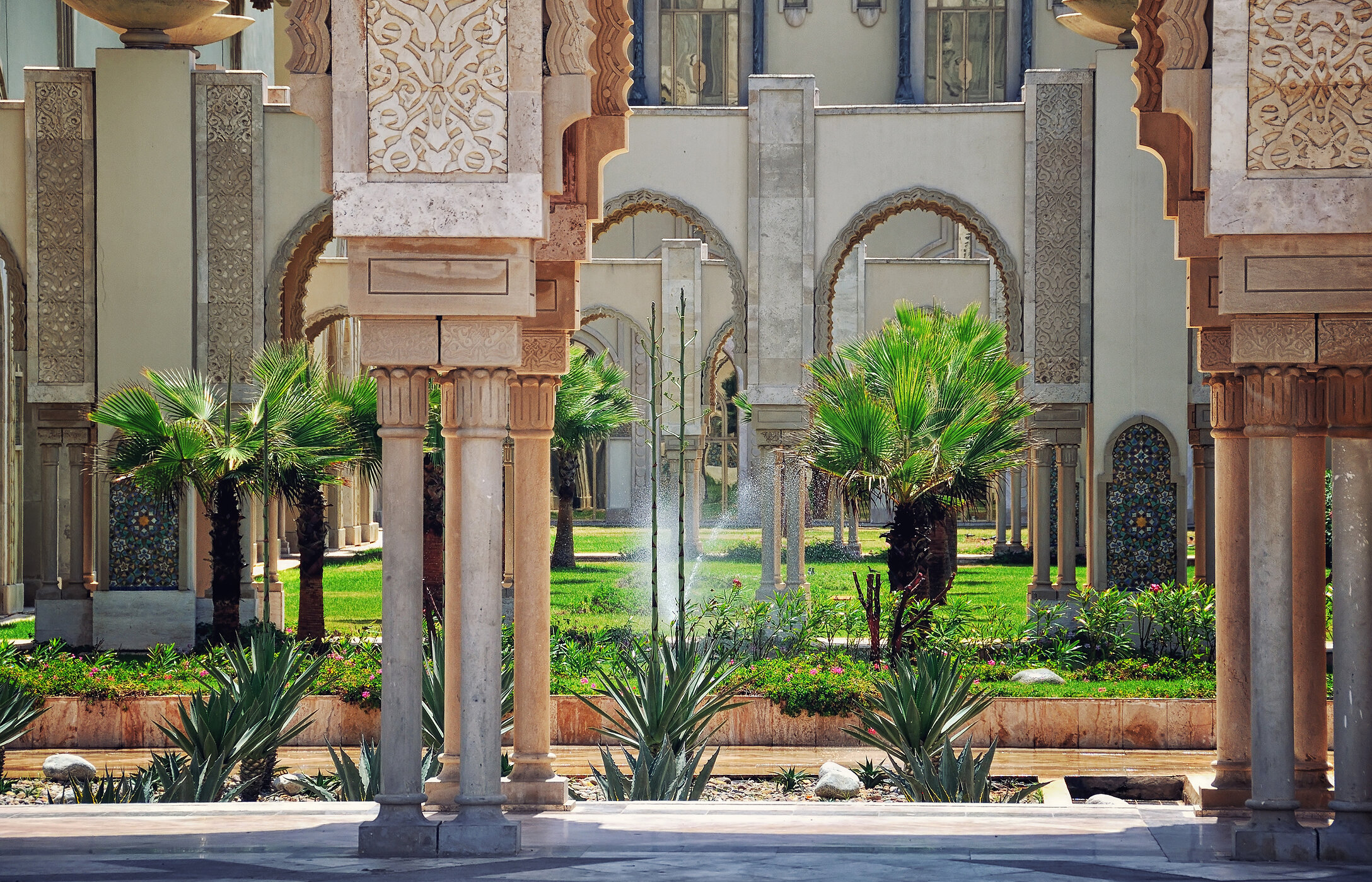 Interior view of the gardens of Hassan II Mosque, filled with lawns and trees