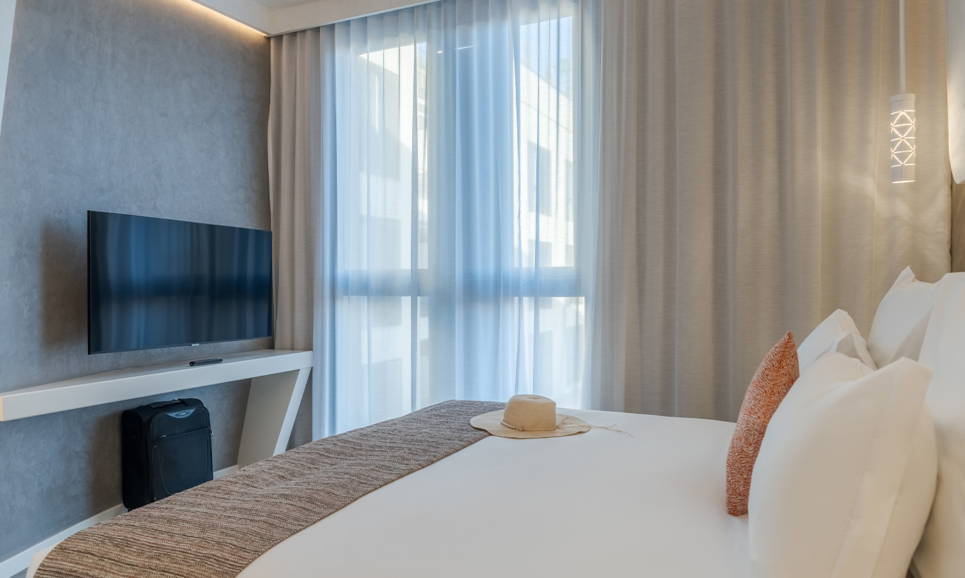 The CR7 Suite at Pestana CR7 Marrakech has a room with a double bed, TV, and a window with curtains