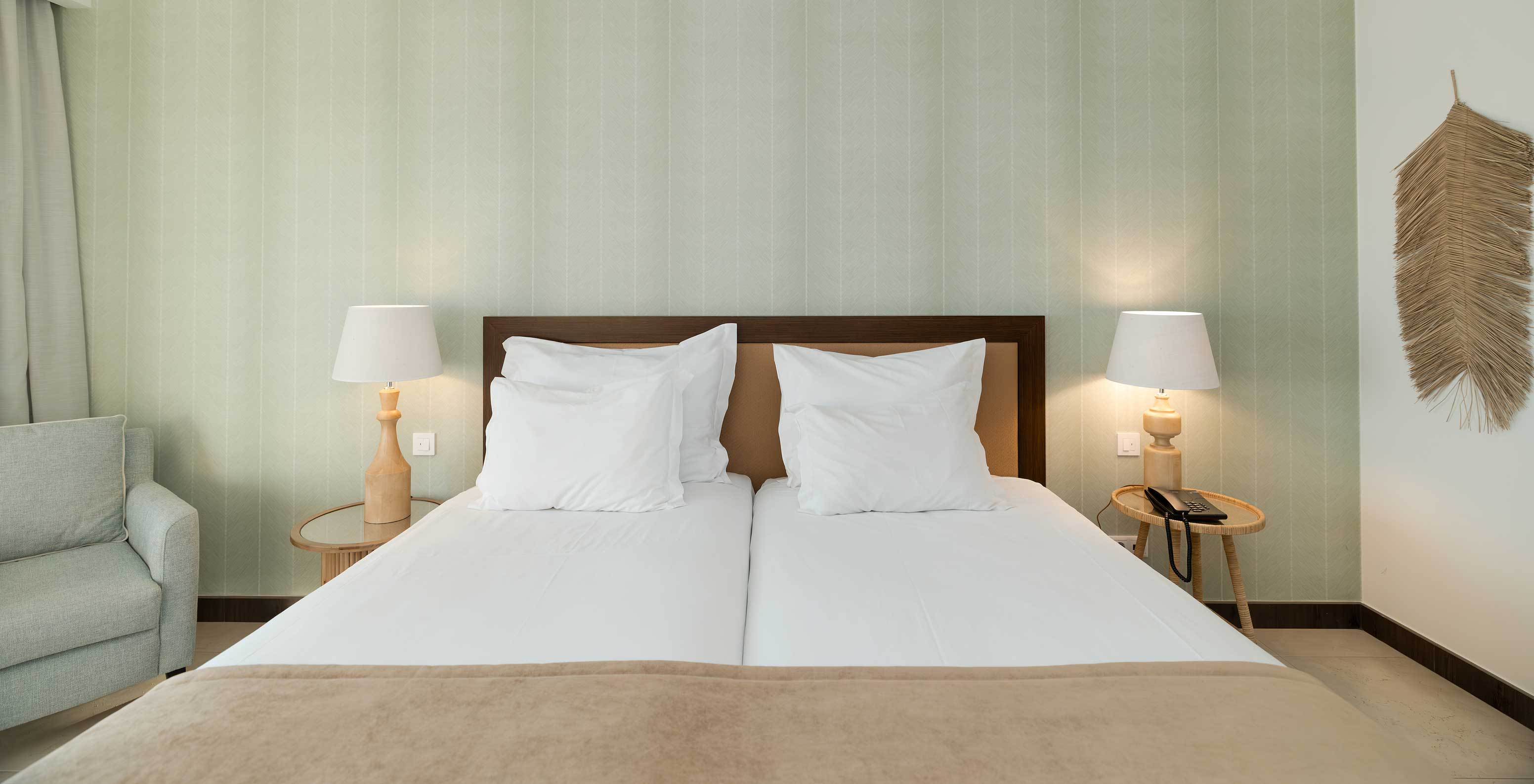 Studio Garden View at Pestana Alvor Beach Villas has two beds with bedside table and green wallpaper