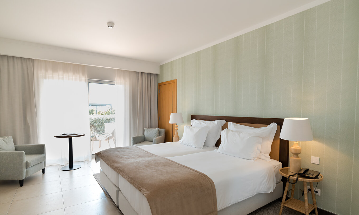 Studio Garden View at Pestana Alvor Beach Villas has two beds, green wallpaper and window with balcony