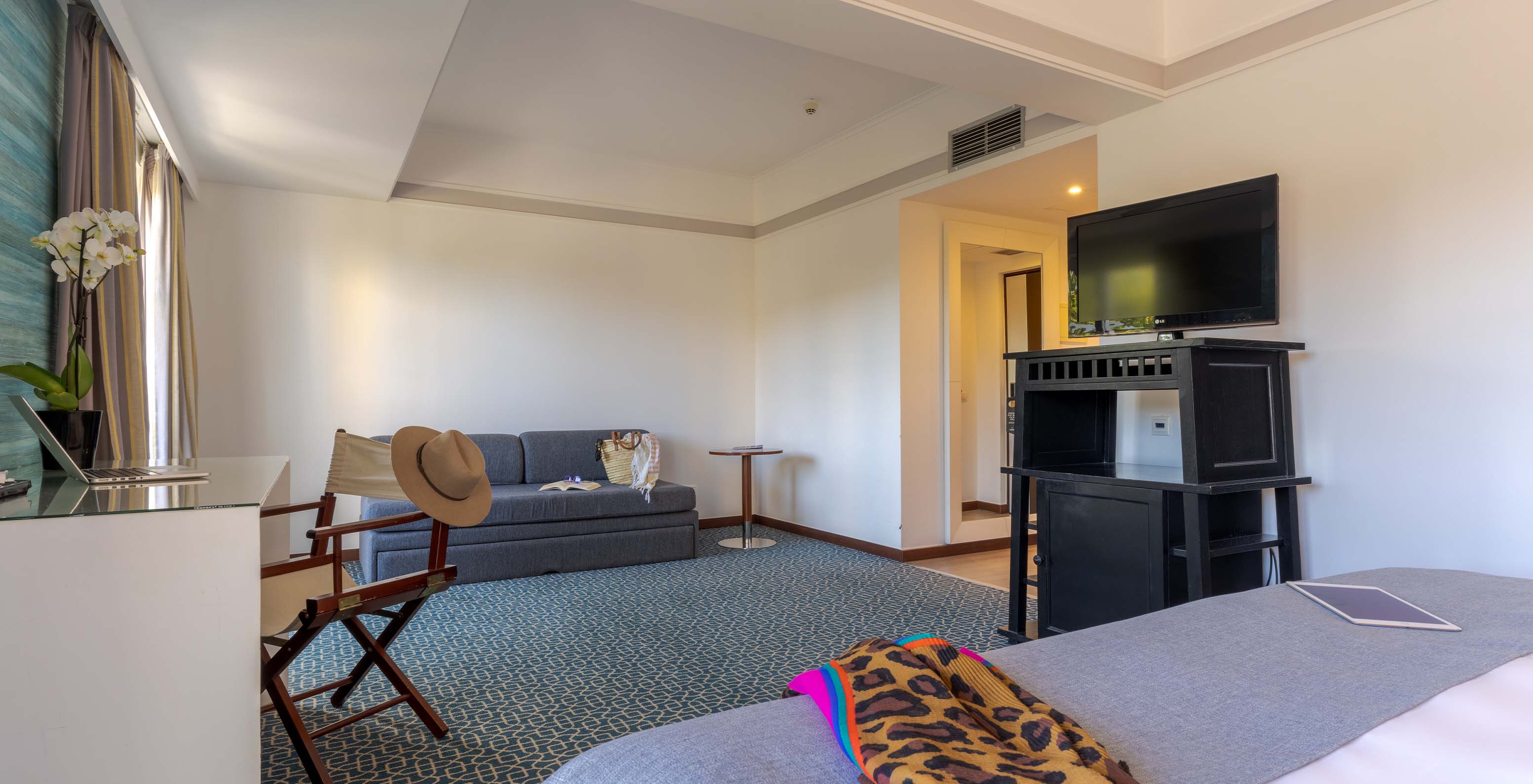 The Superior at Pestana Alvor Praia has a double bed, a black unit with TV, a sofa bed, and a desk