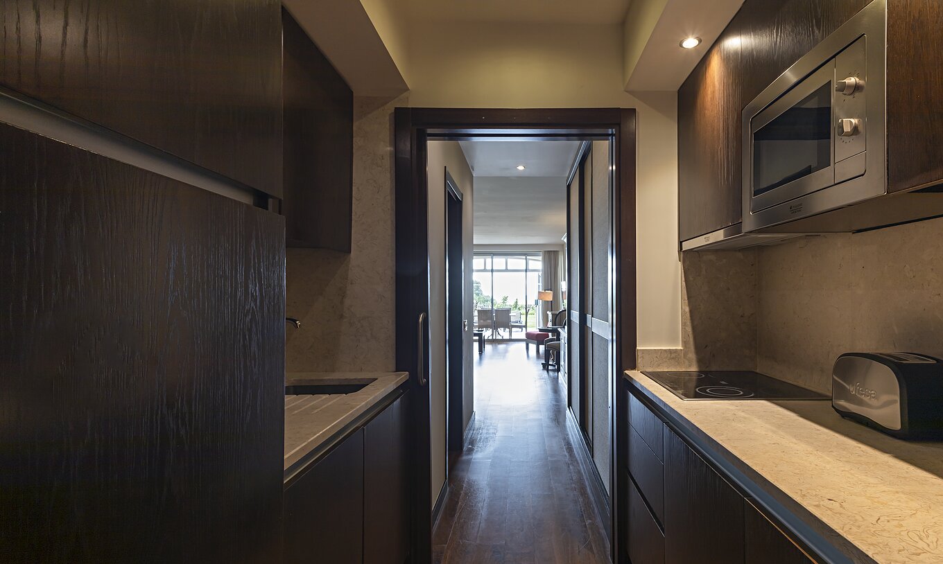 The Cliff Family at Pestana Alvor Praia has a fully equipped kitchen in dark wood and stone, with a stove and a microwave