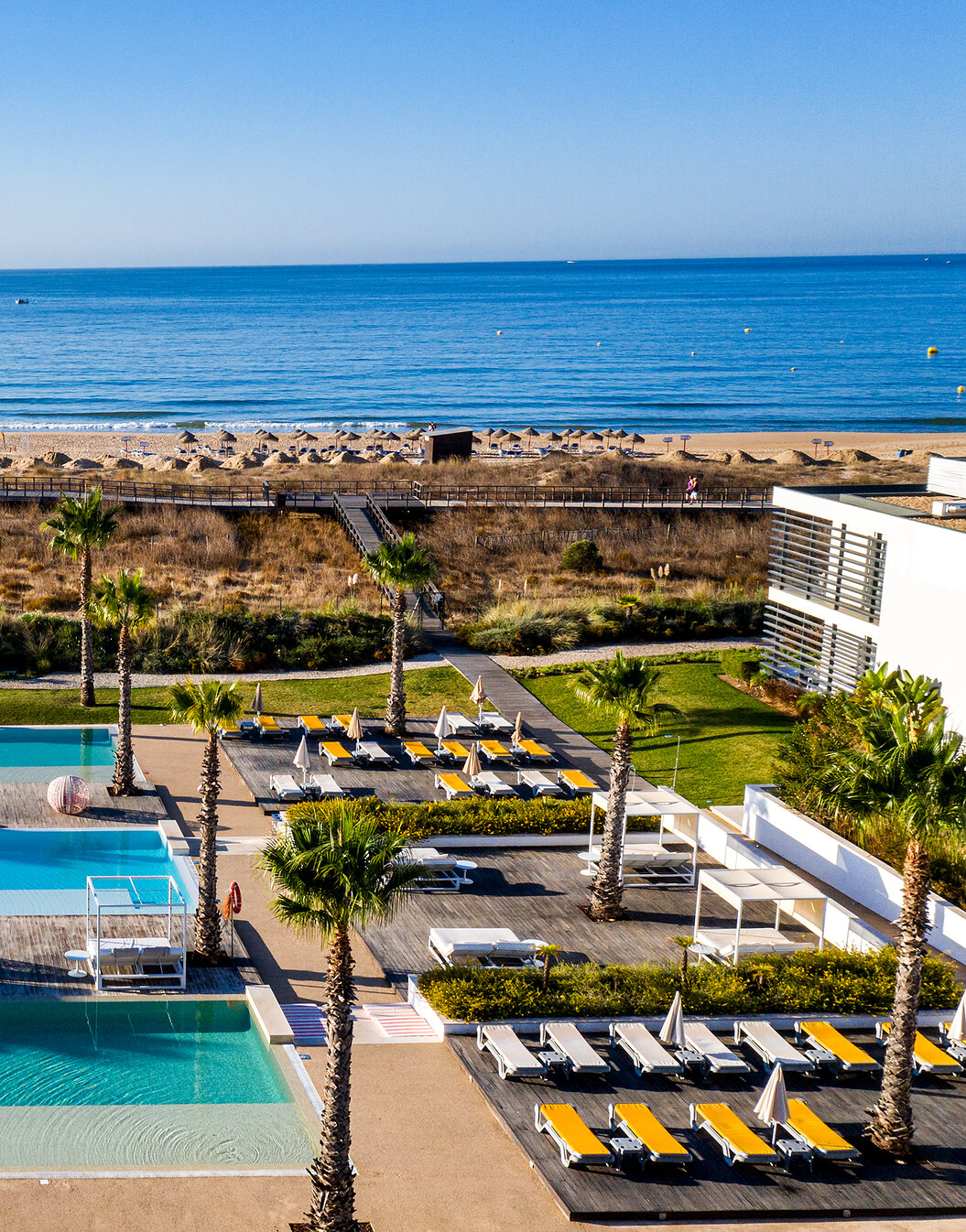 Outdoor area of the pools and sun loungers at Pestana Alvor South Beach, with direct access to the beach