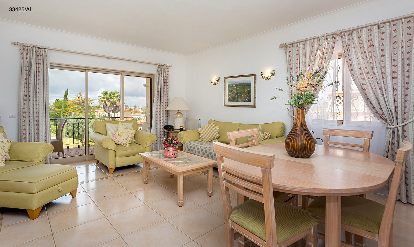 The Pestana Carvoeiro Golf T2 Standard Apartment has a living room with green sofas and a round table