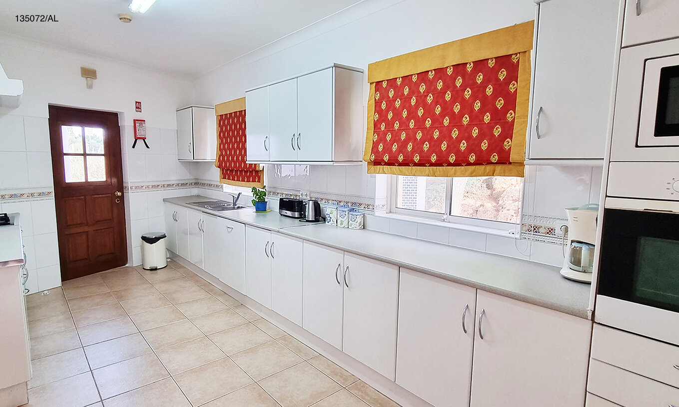 The Pestana Carvoeiro Golf V3 Standard Villa has a kitchen equipped with white cabinets and appliances
