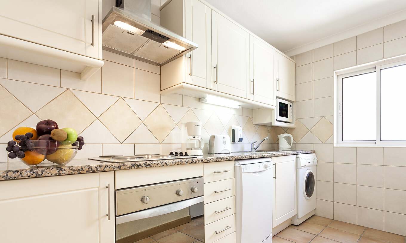 The T1 Apartment Standard do Pestana Palm Gardens has a kitchenette with a stove, a washing machine and dishes