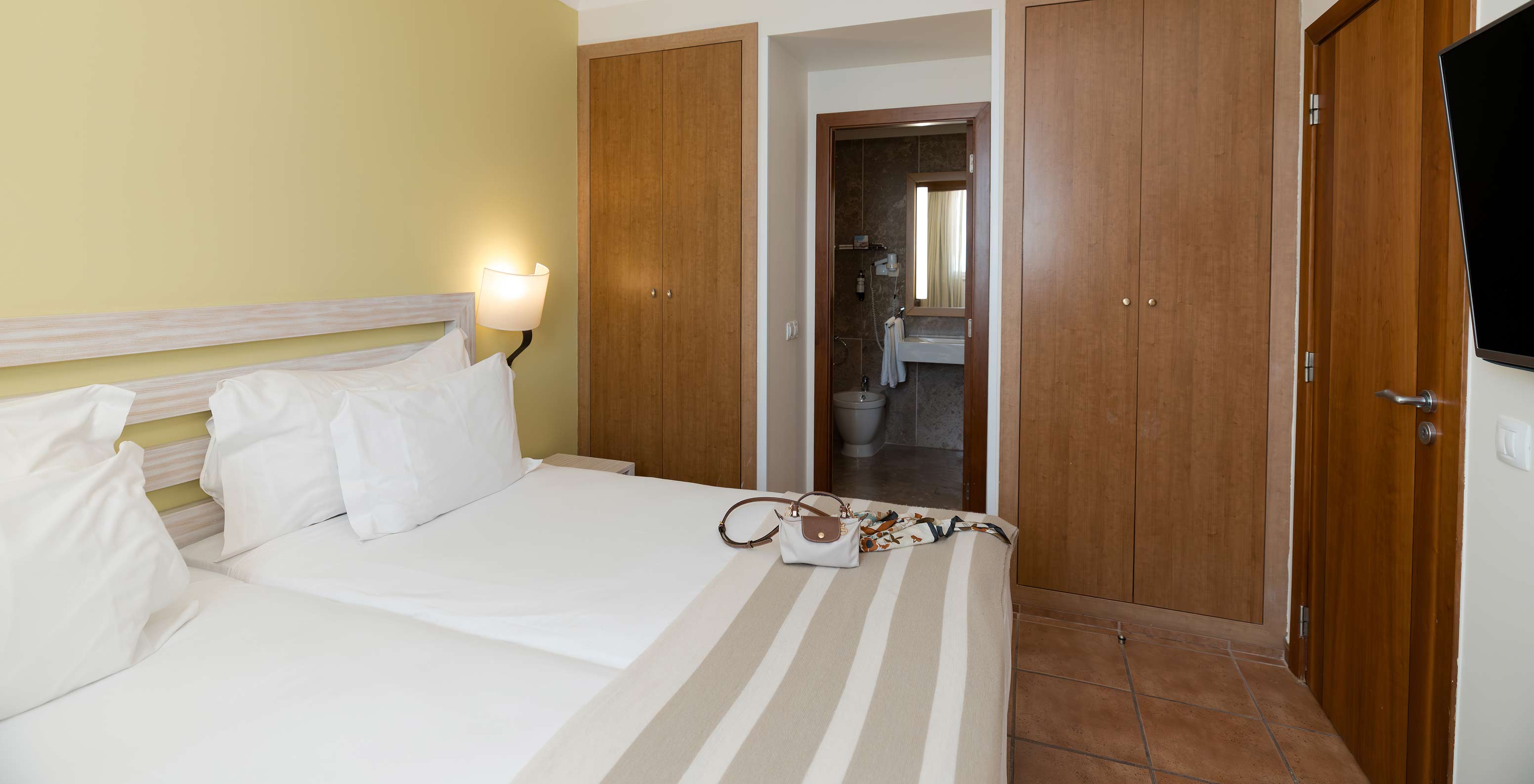 The T2 Suite at Pestana Viking has a room with two beds, bedside table and bathroom