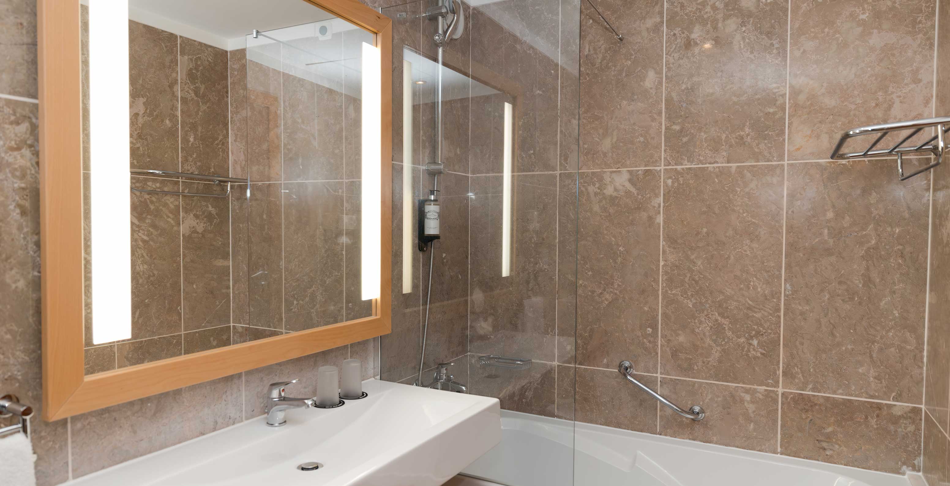 The Deluxe Side Sea View at Pestana Viking has a bathroom with sink, large mirror and bathtub with shower