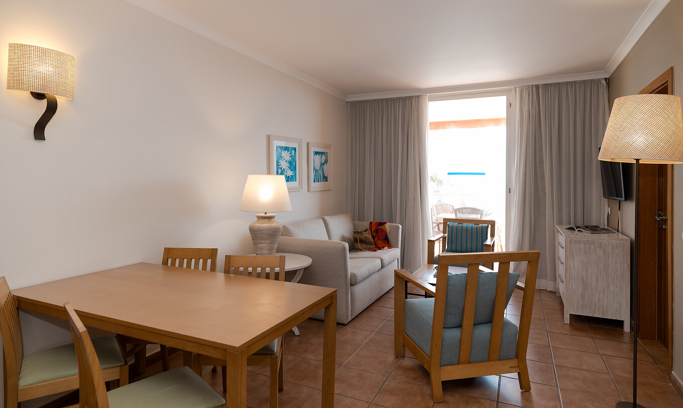 The T2 Suite at Pestana Viking has a living room with sofa, two armchairs and window with balcony access