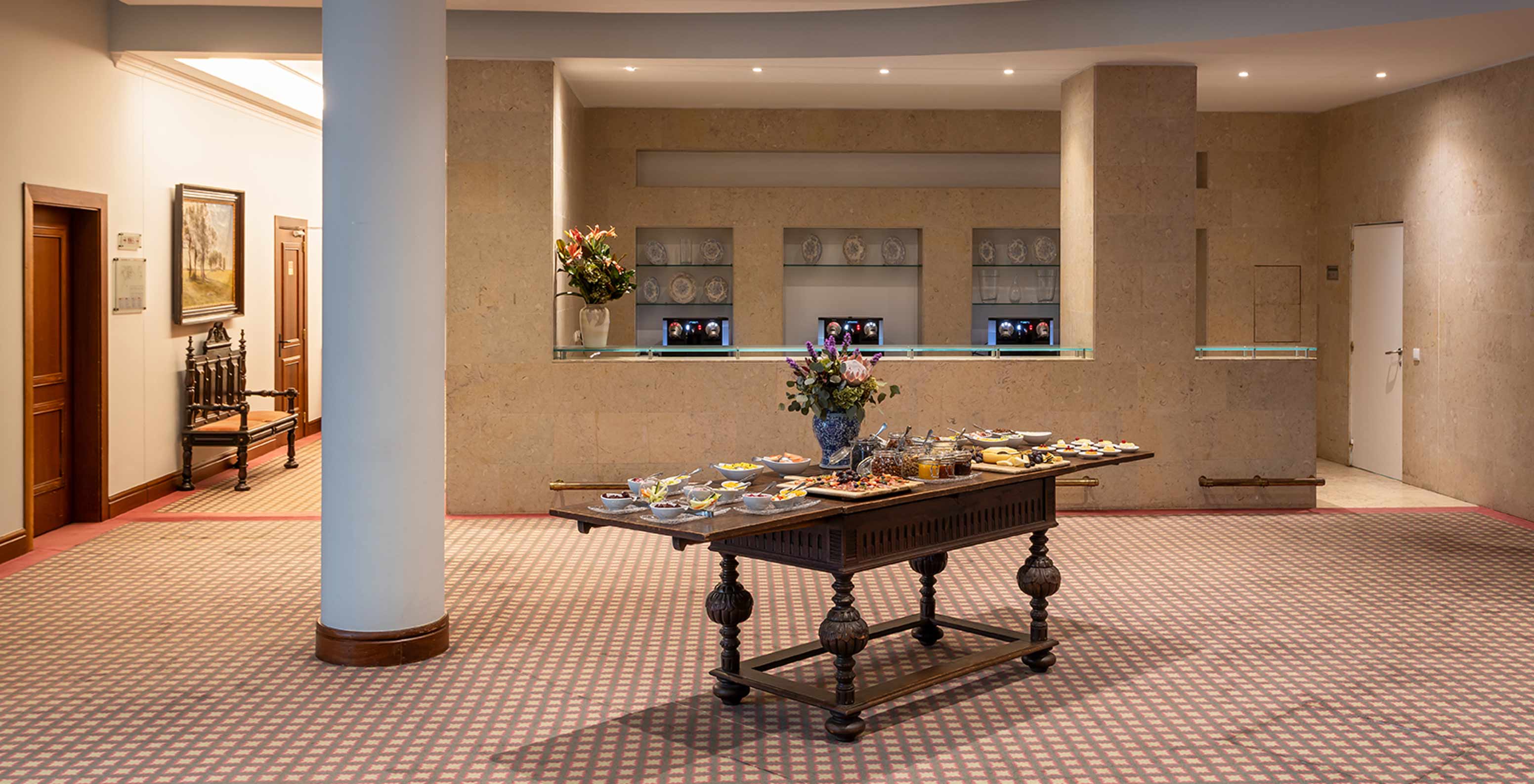 Pestana Palace Lisboa has a carpeted event room with a table with snacks and a vase of flowers