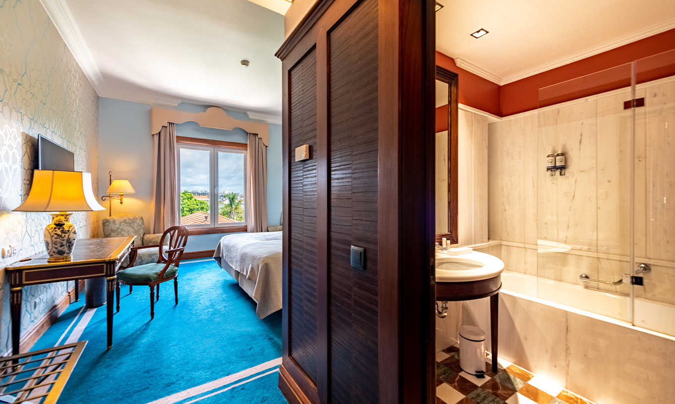 The Premium Garden room at Pestana Palace Lisbon includes an entrance hallway, wooden desk, television, and a window