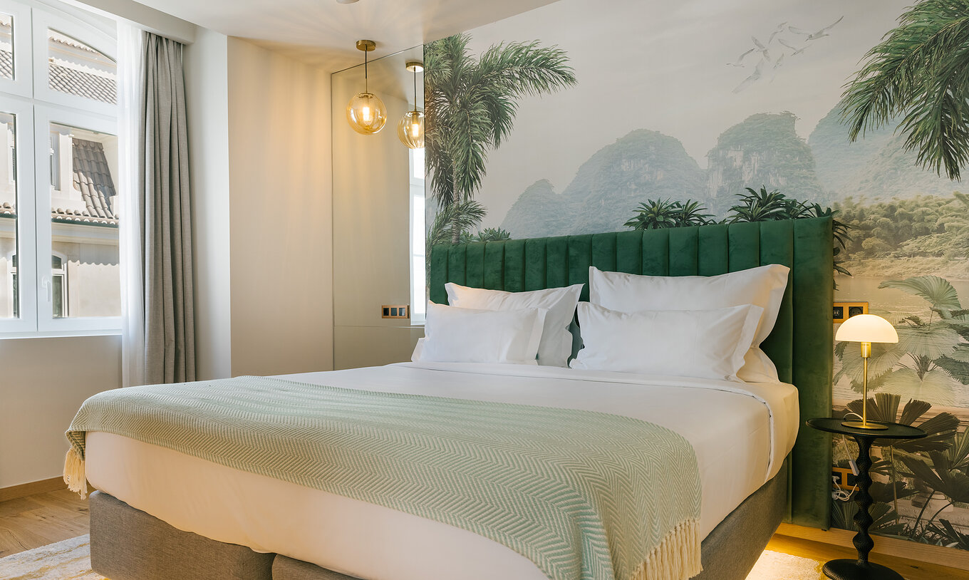 The Premium Corner of Pestana Rua Augusta Lisboa has a double bed, palm wallpaper, and a window with curtains