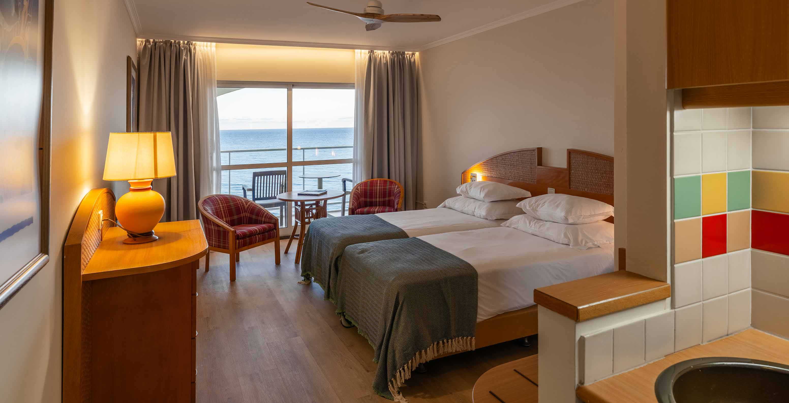 The Pestana Ocean Bay All Inclusive Superior Sea View has a double bed, two armchairs, and a balcony with sea view
