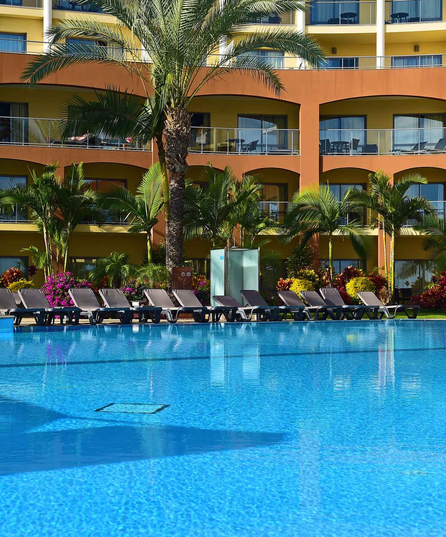 Pestana Promenade a hotel in Madeira near the beach and Lido has an outdoor pool with several loungers