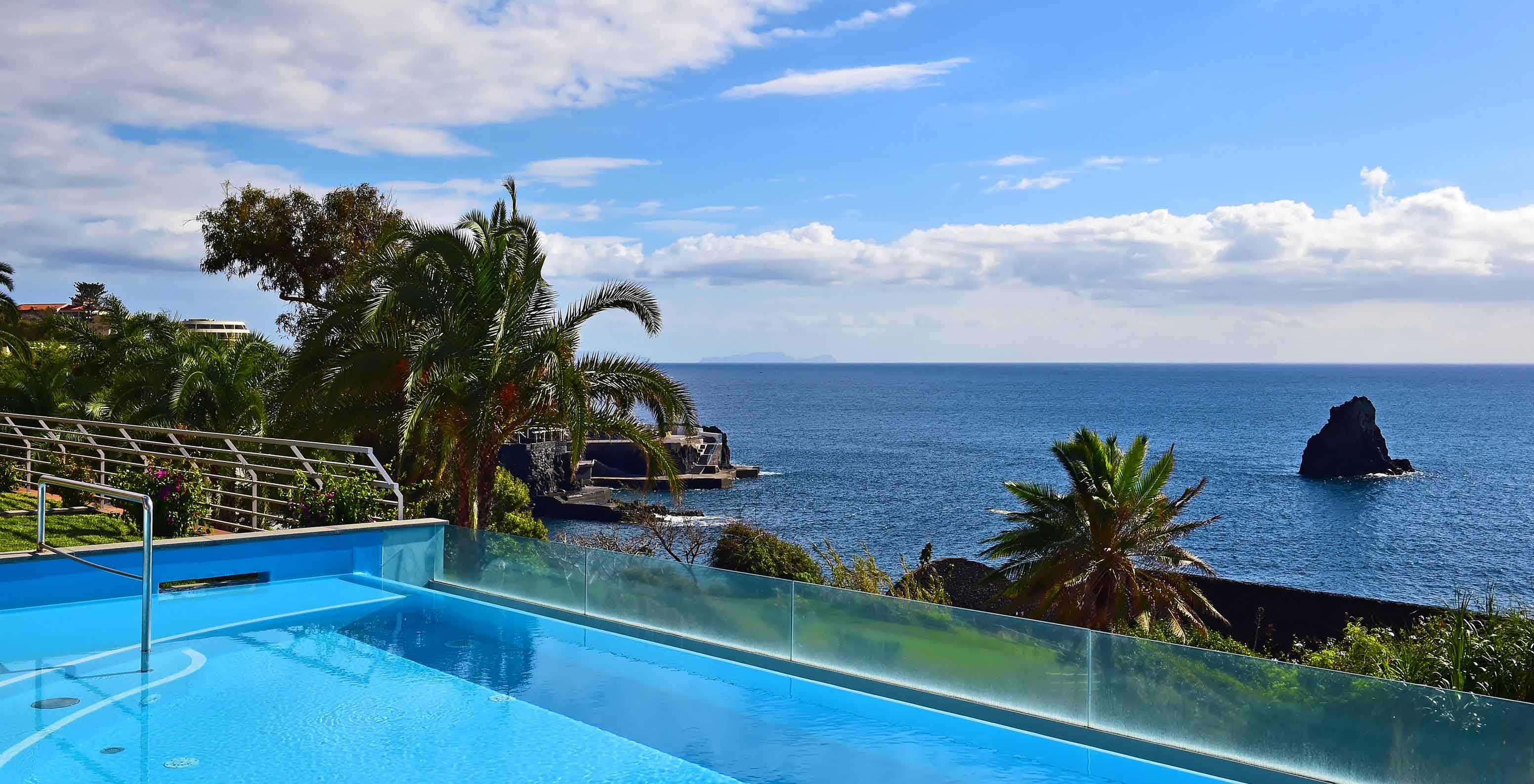 Infinity outdoor pool at Pestana Promenade, hotel in Madeira, near the beach and Lido, with sea view and palm trees