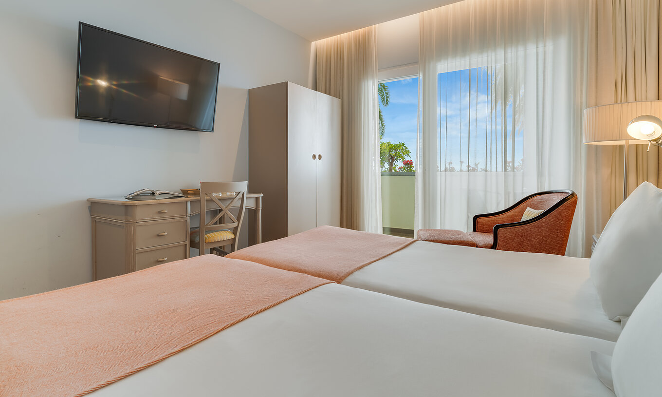 The Classic Twin Promenade View of Pestana Promenade has a mounted television in front of the bed and a balcony