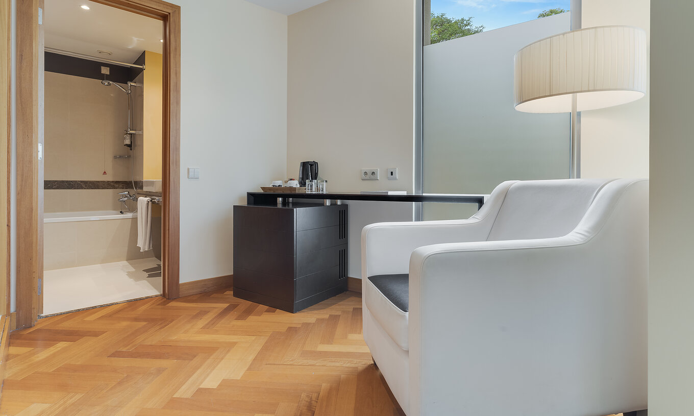 The Classic Twin of Pestana Promenade has a bathroom with bathtub and has an armchair and a table at the door