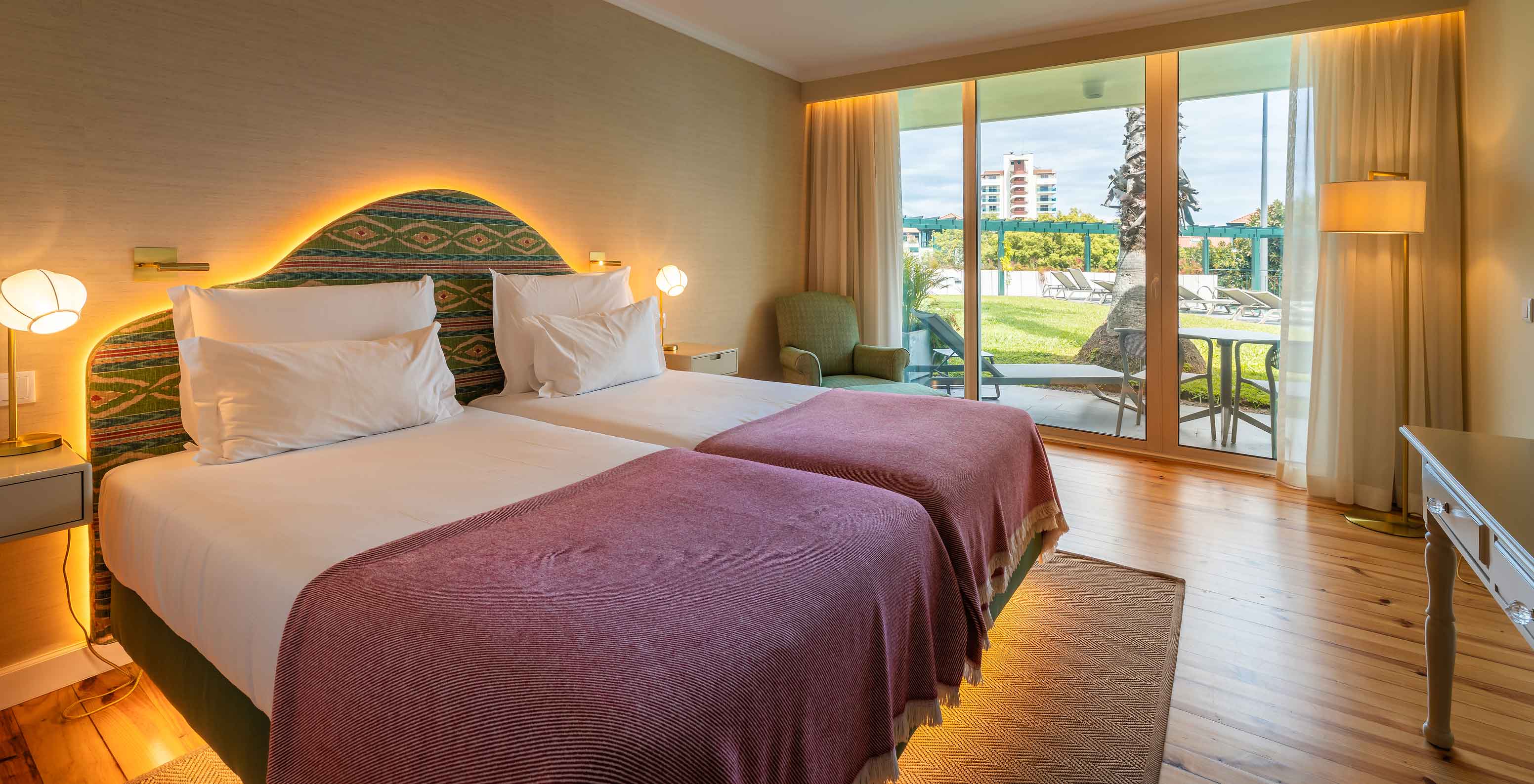The Pool View Room at Pestana Quinta Perestrello has a double bed, an armchair, and a balcony overlooking the garden.