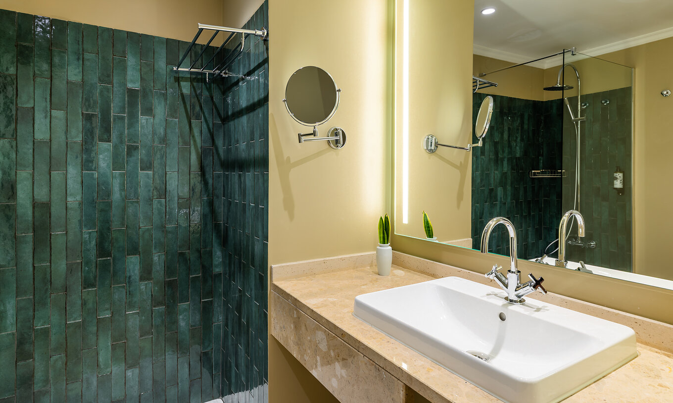 The Partial Sea View Room at Pestana Quinta Perestrello has a bathroom with a washbasin, mirror and green tiles.