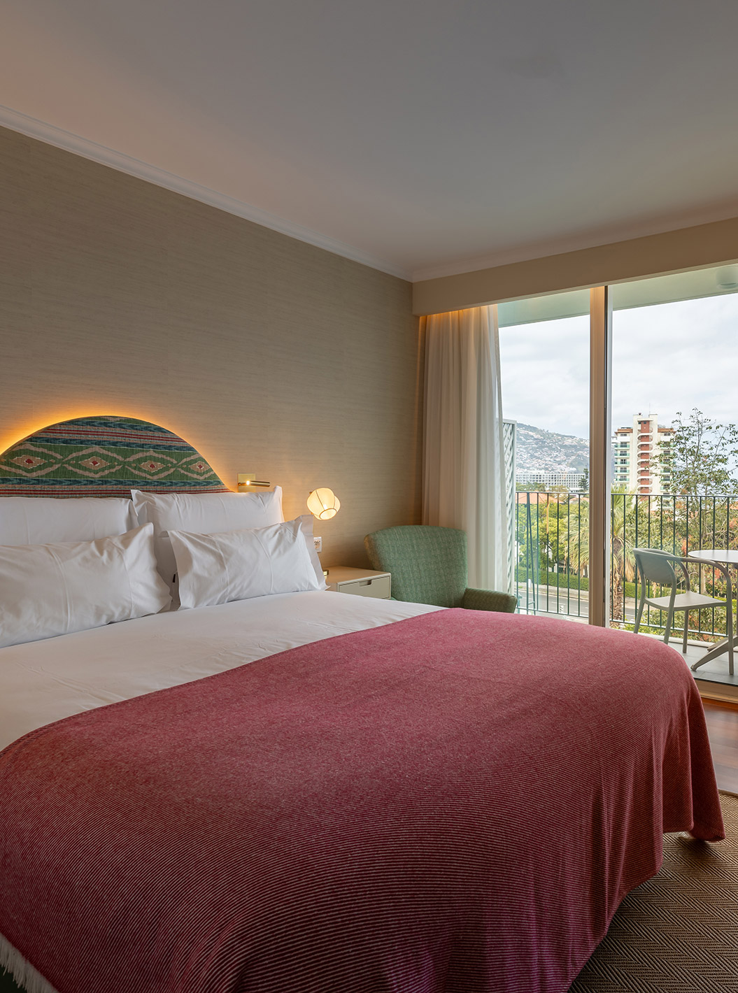 The Partial Sea View Room at Pestana Quinta Perestrello has a double bed, a balcony with a table, chairs, and a sea view.