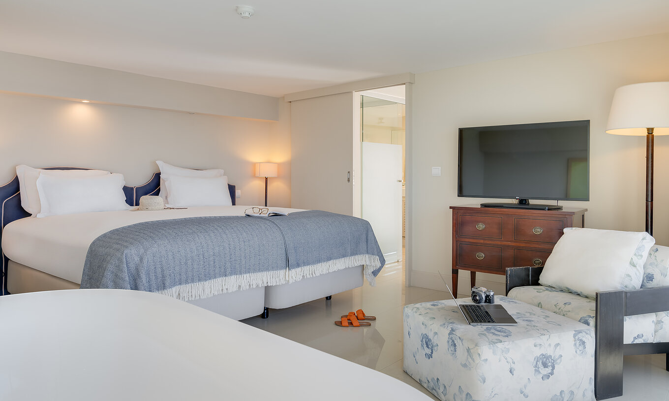 The Duplex Sea View Suite at Pestana Vila Lido Madeira features a double bed, a chaise longue, and a television